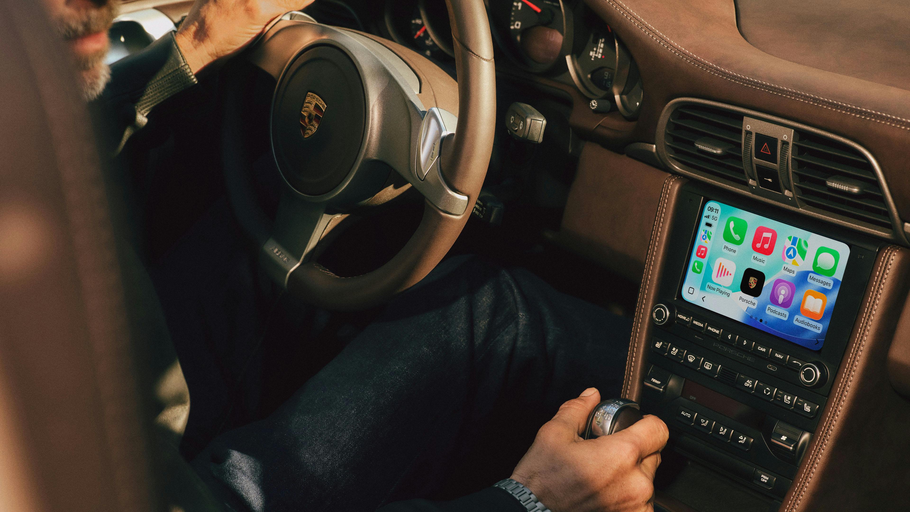 Innenraum eines Porsche 911 mit PCCM Plus Touchdisplay, auf dem eine App‑Übersicht angezeigt wird