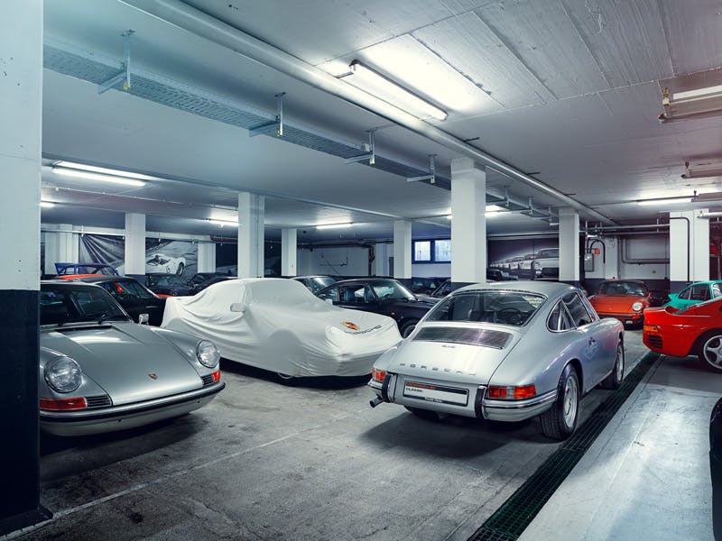 Various Porsche models in a garage.