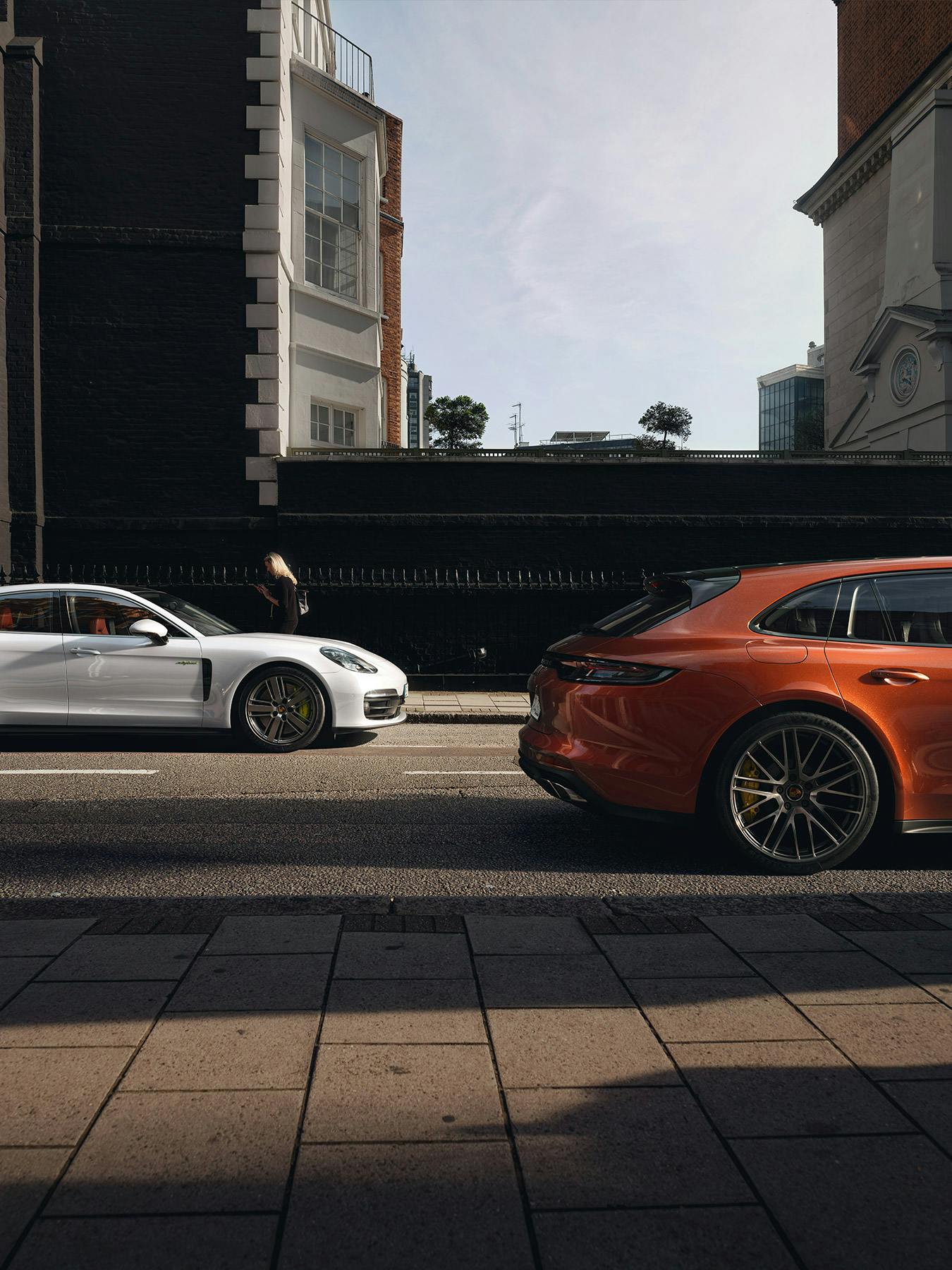 Panamera models in an urban environment driving by each other.