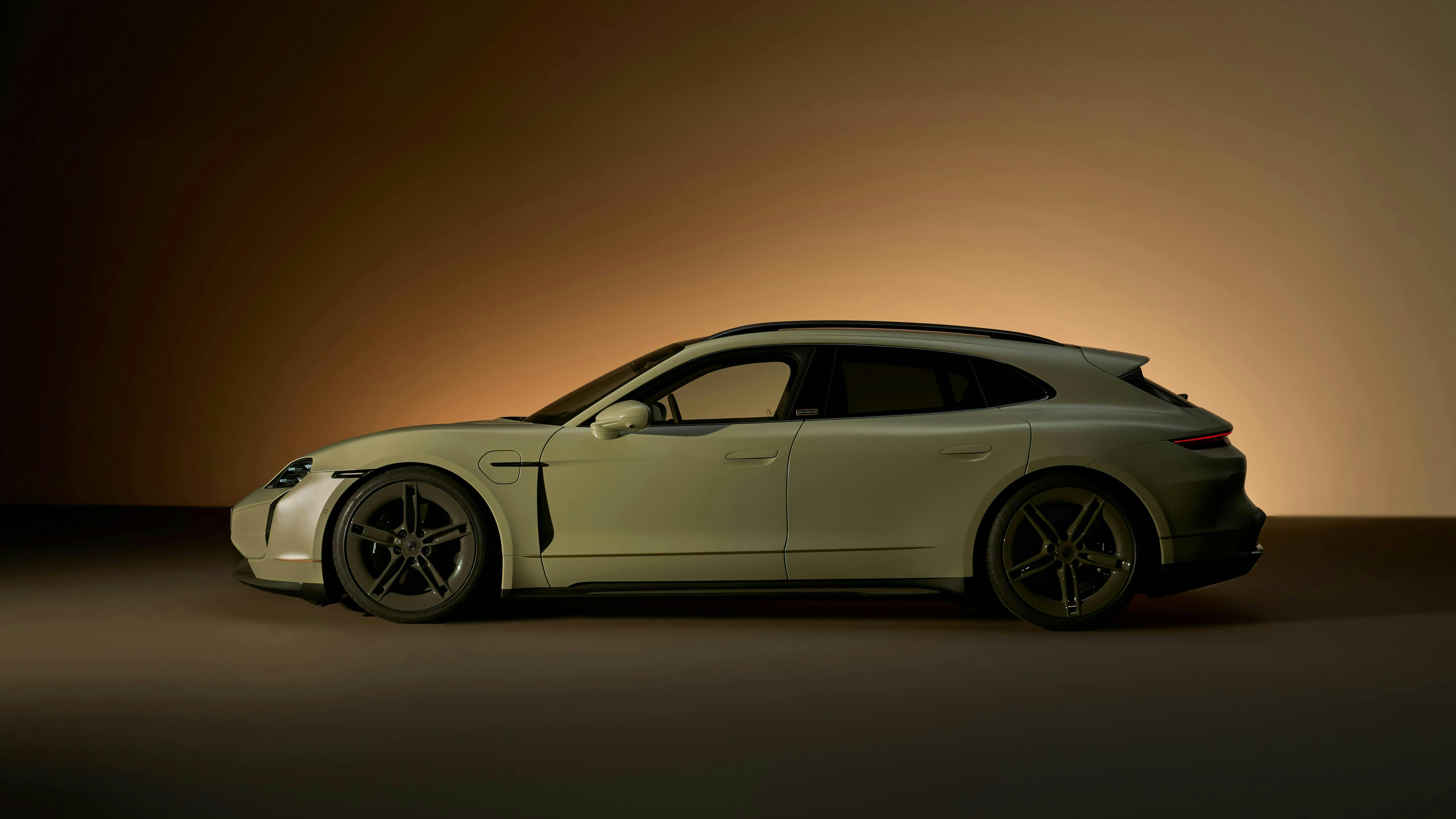 Side profile of the Taycan Turbo S Soho House One in satin Greek Street Green, lit against a dark studio backdrop.