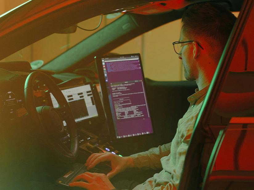 Der Porsche Mitarbeiter Mathias prüft in einem Testfahrzeug unterschiedliche Fahrfunktionen für das hochautomatisierte Fahrsystem.