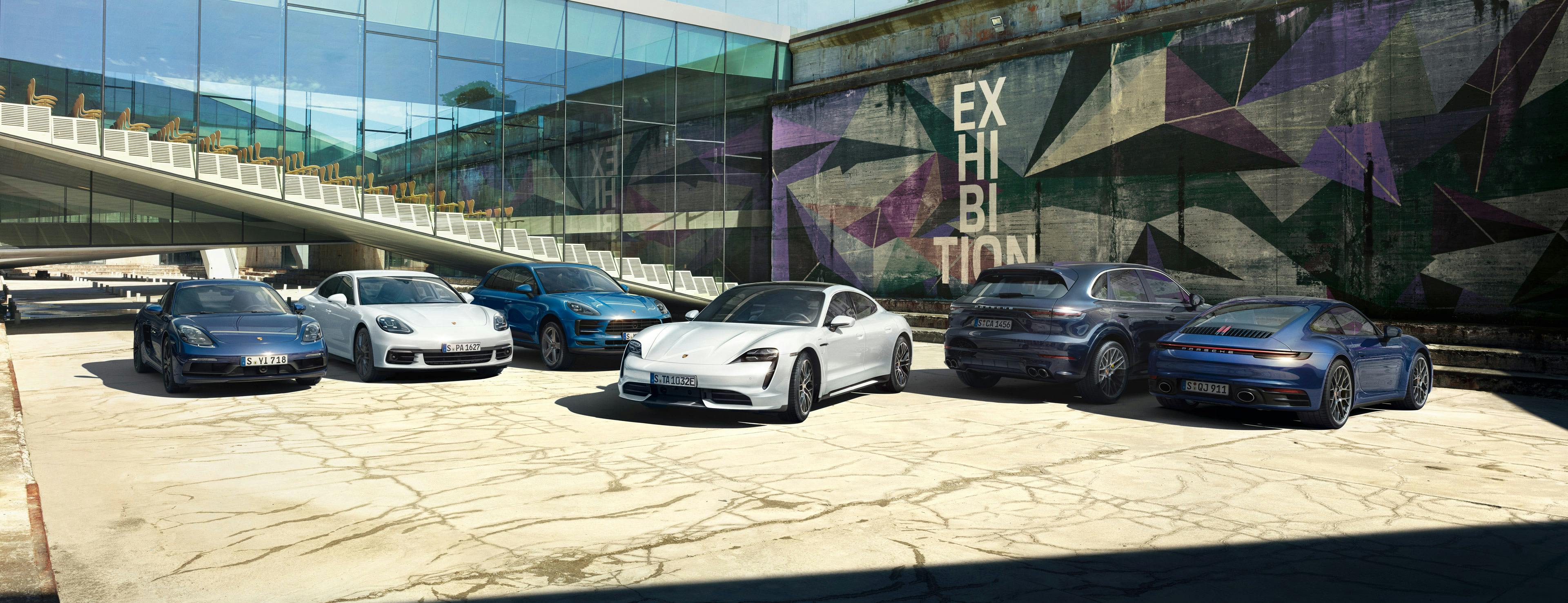 Various Porsche models in front of a building.