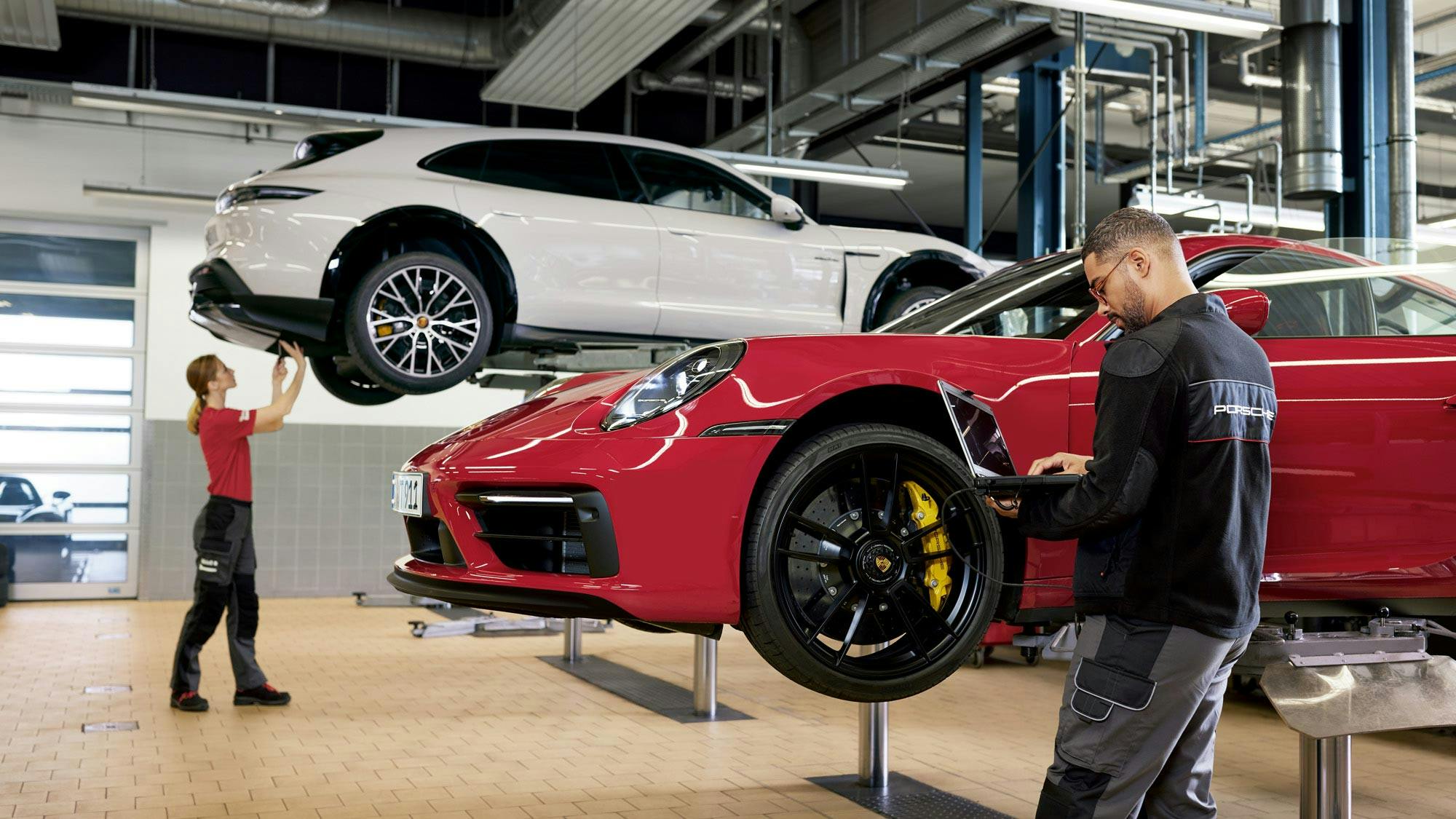 Porsche mechanic connecting his laptop to a vehicle.