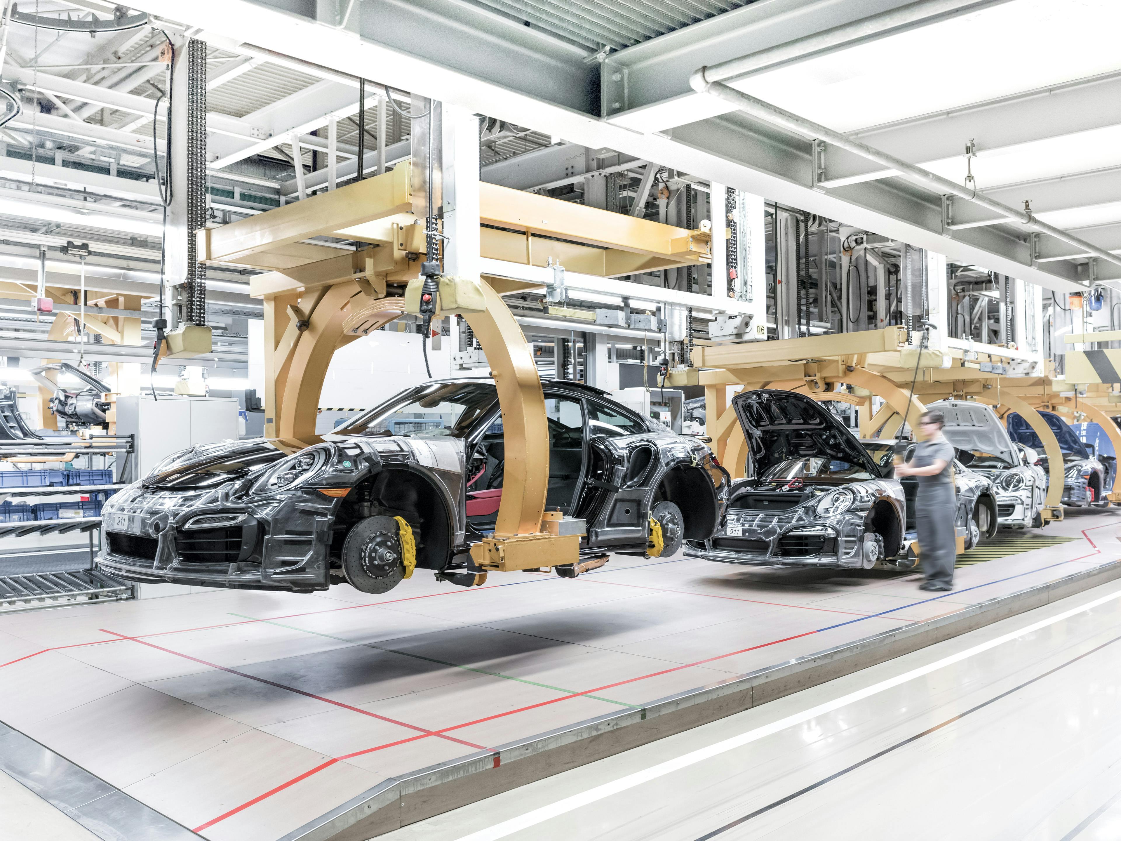 Des modèles Porsche 911 sur la chaîne de montage de l'usine de Stuttgart-Zuffenhausen, équipés de châssis de fixation de la carrosserie en bois.