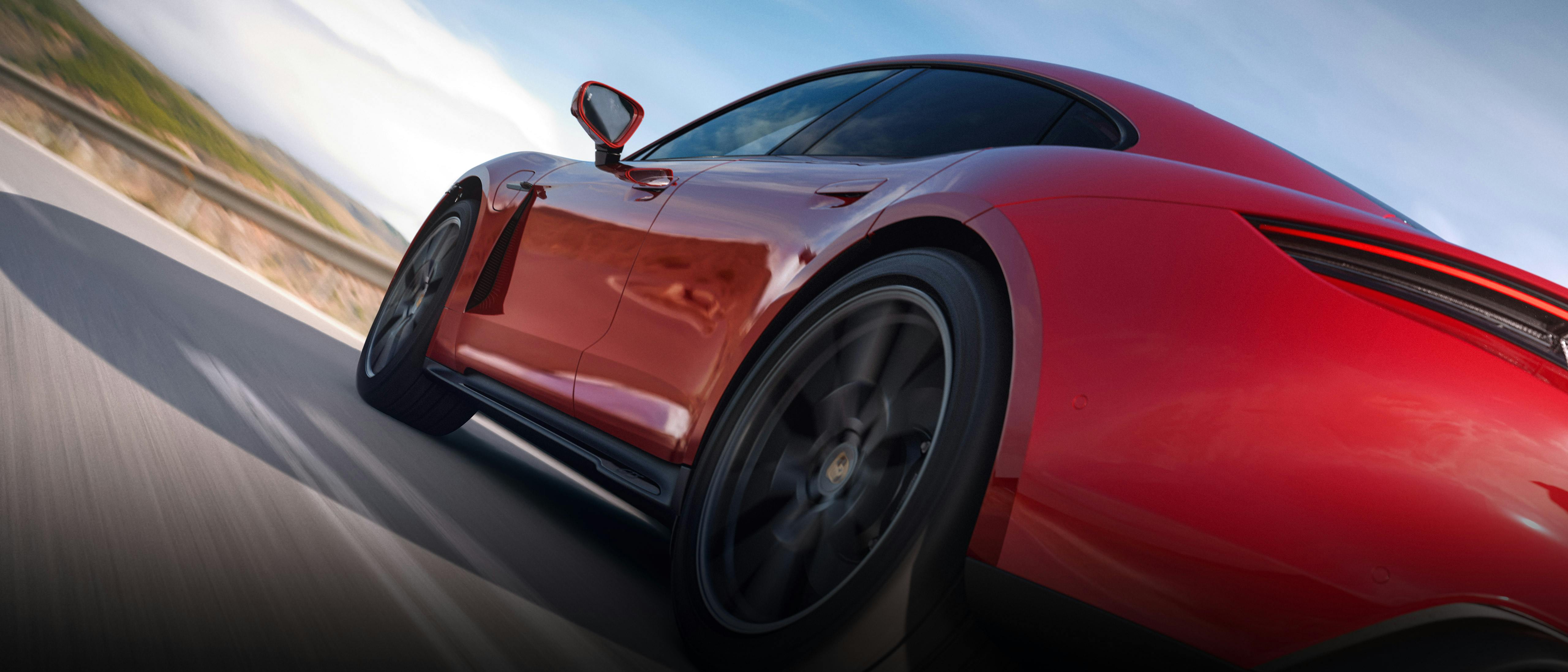 Dynamische Nahaufnahme der hinteren Seitenpartie eines roten Porsche Taycan.