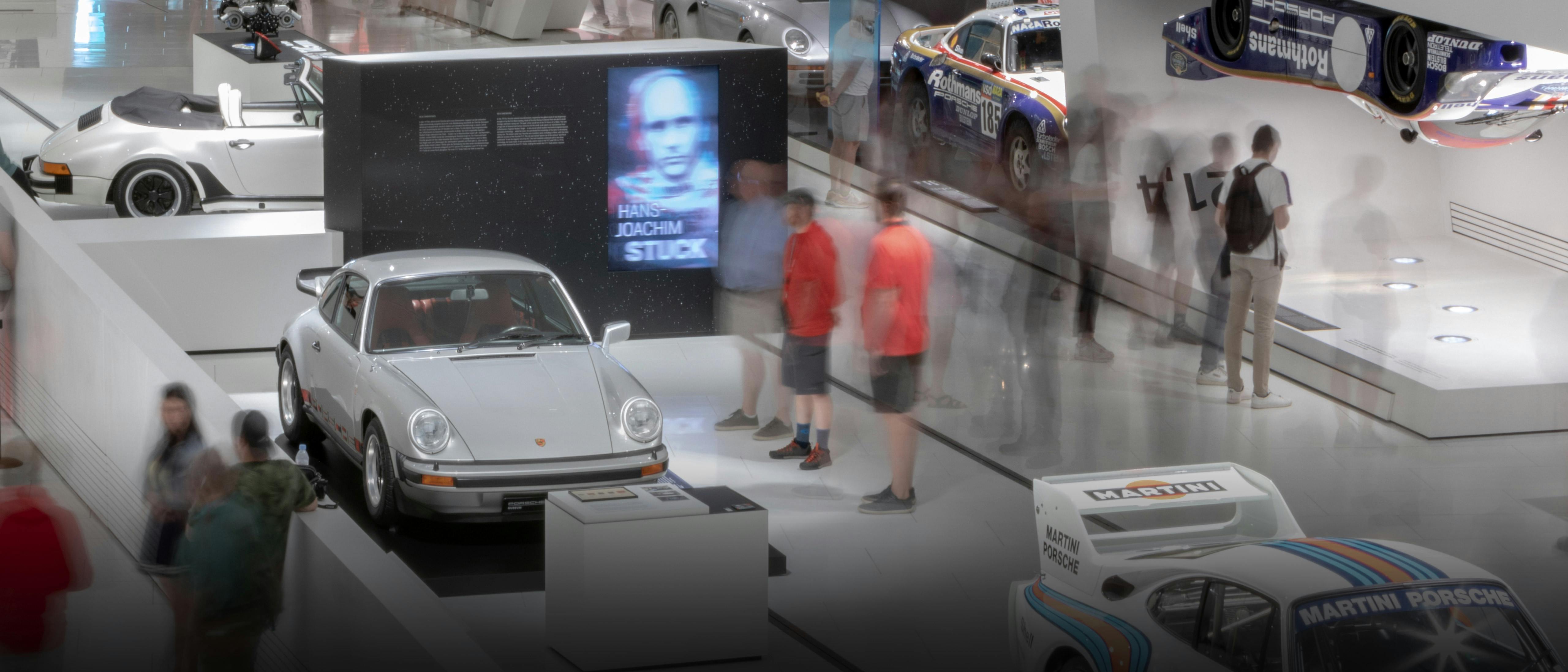 Porsche Museum Besucher schauen sich eine Ausstellung an.