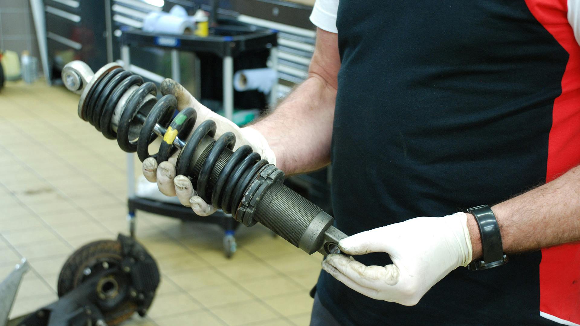 Employee working on a suspension of the Porsche 924 GTP.