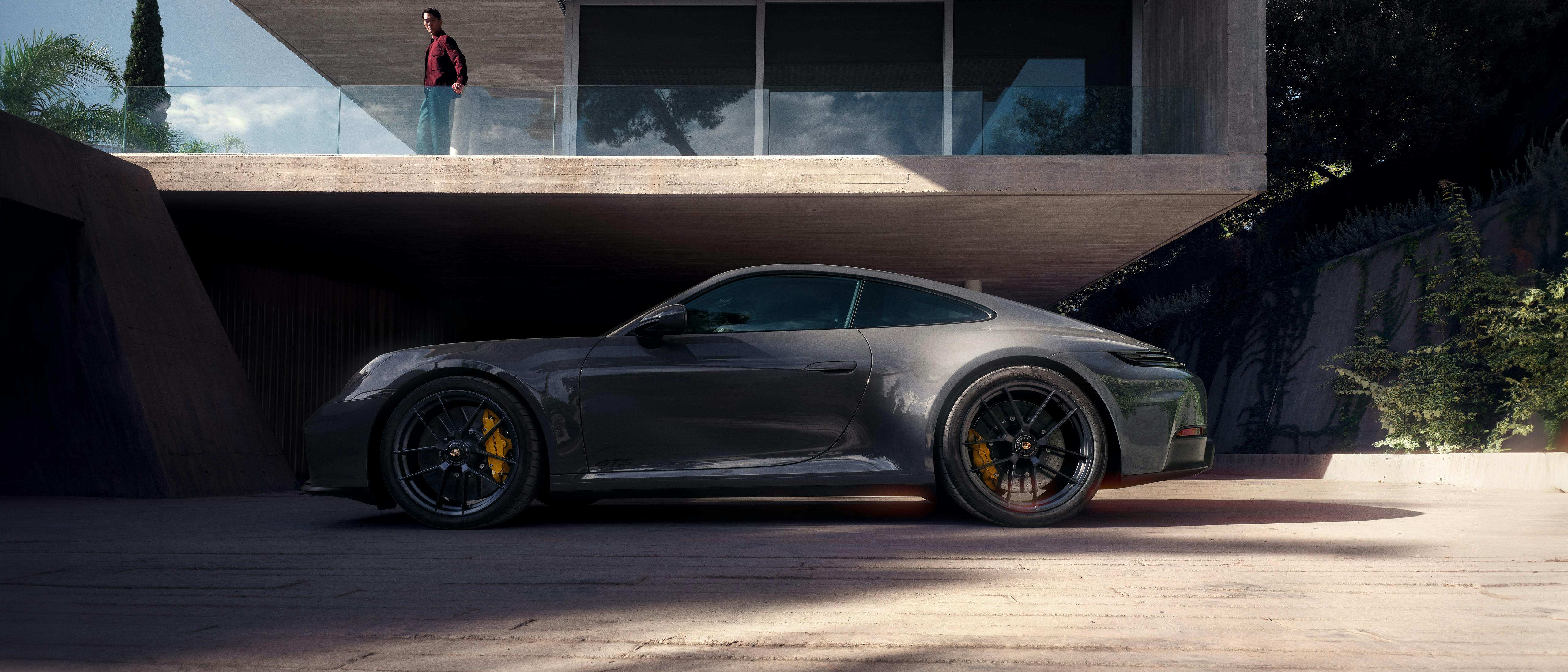 The 911 Carrera GTS in front of a modern house.