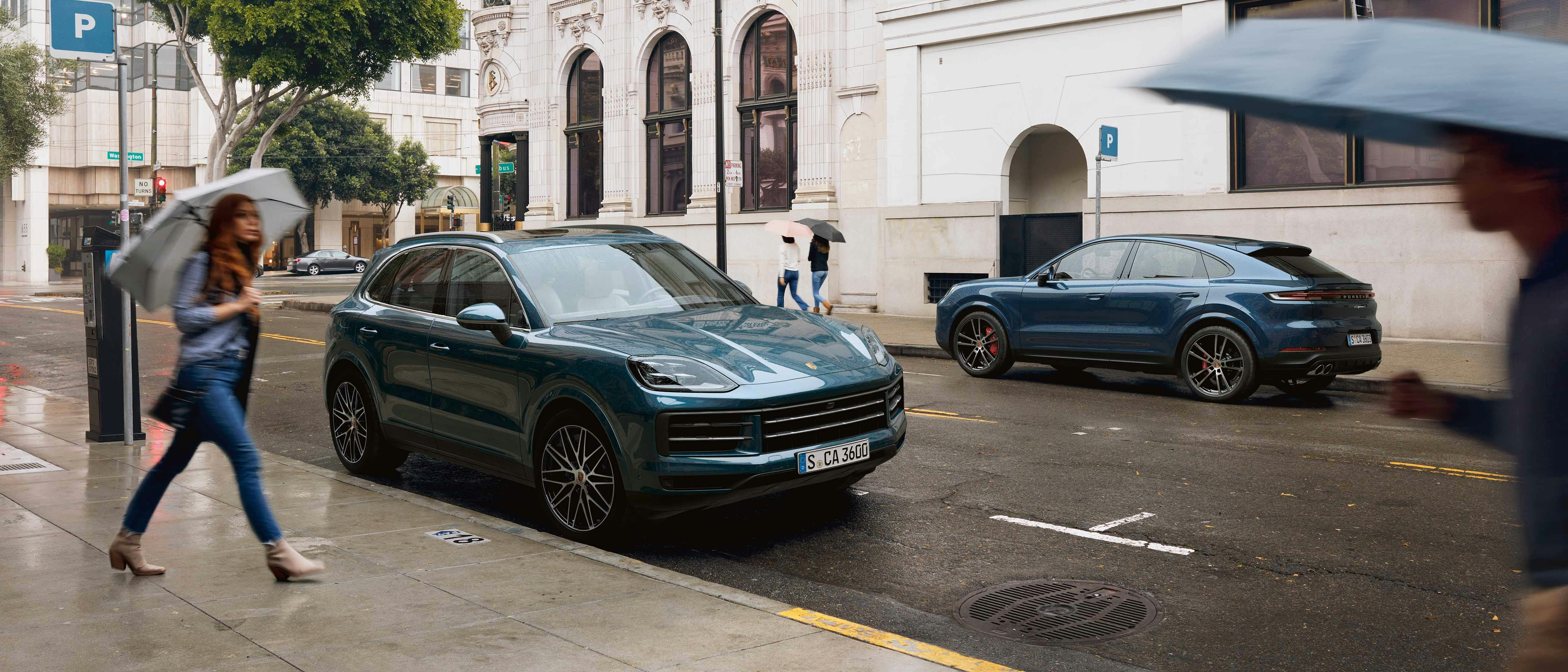 Een Porsche Cayenne staat geparkeerd in een stadse omgeving.