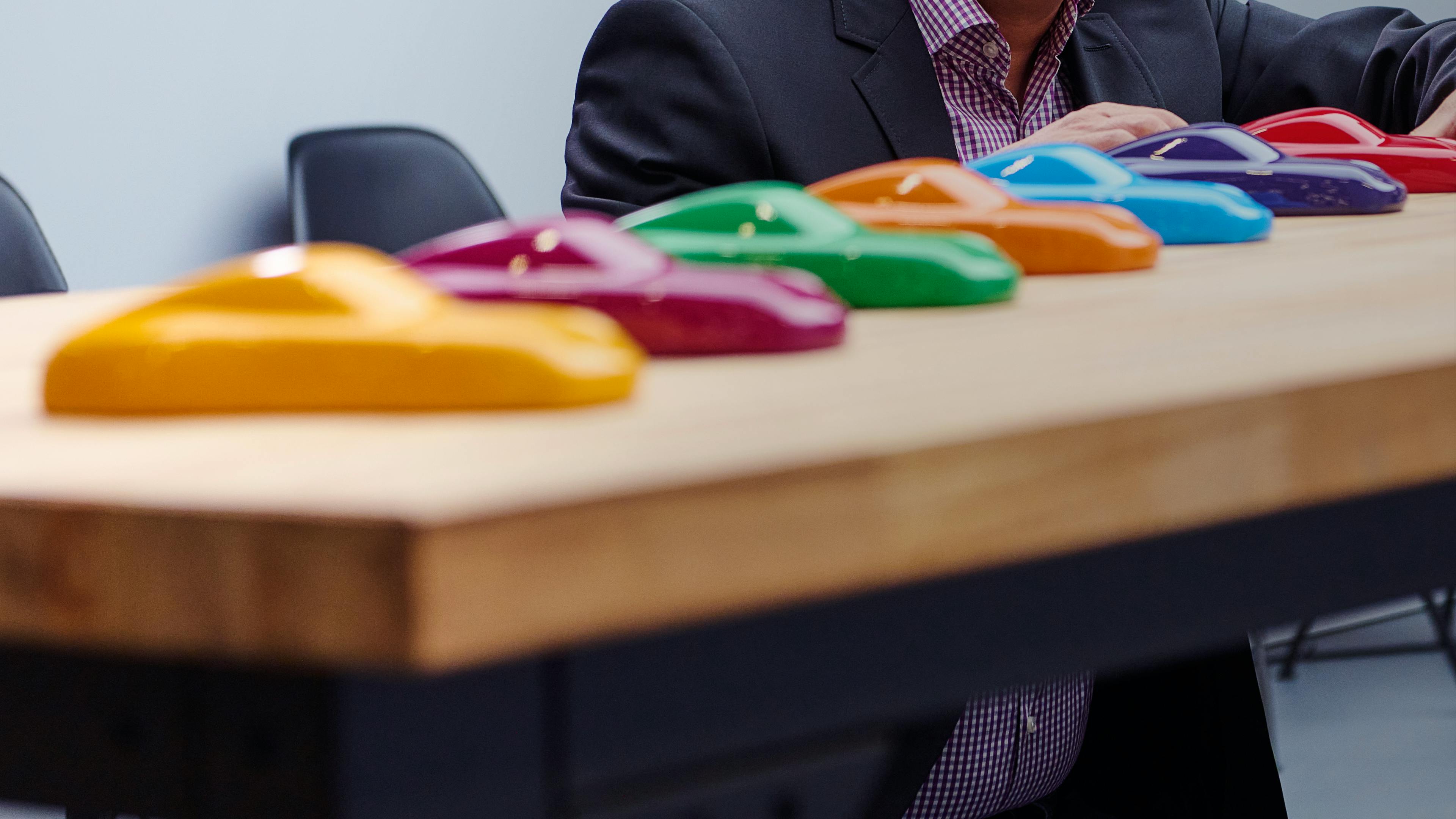 Dreams in Colours: Close-up of paint samples in the form of 911 silhouettes in different strong colours placed in a row.