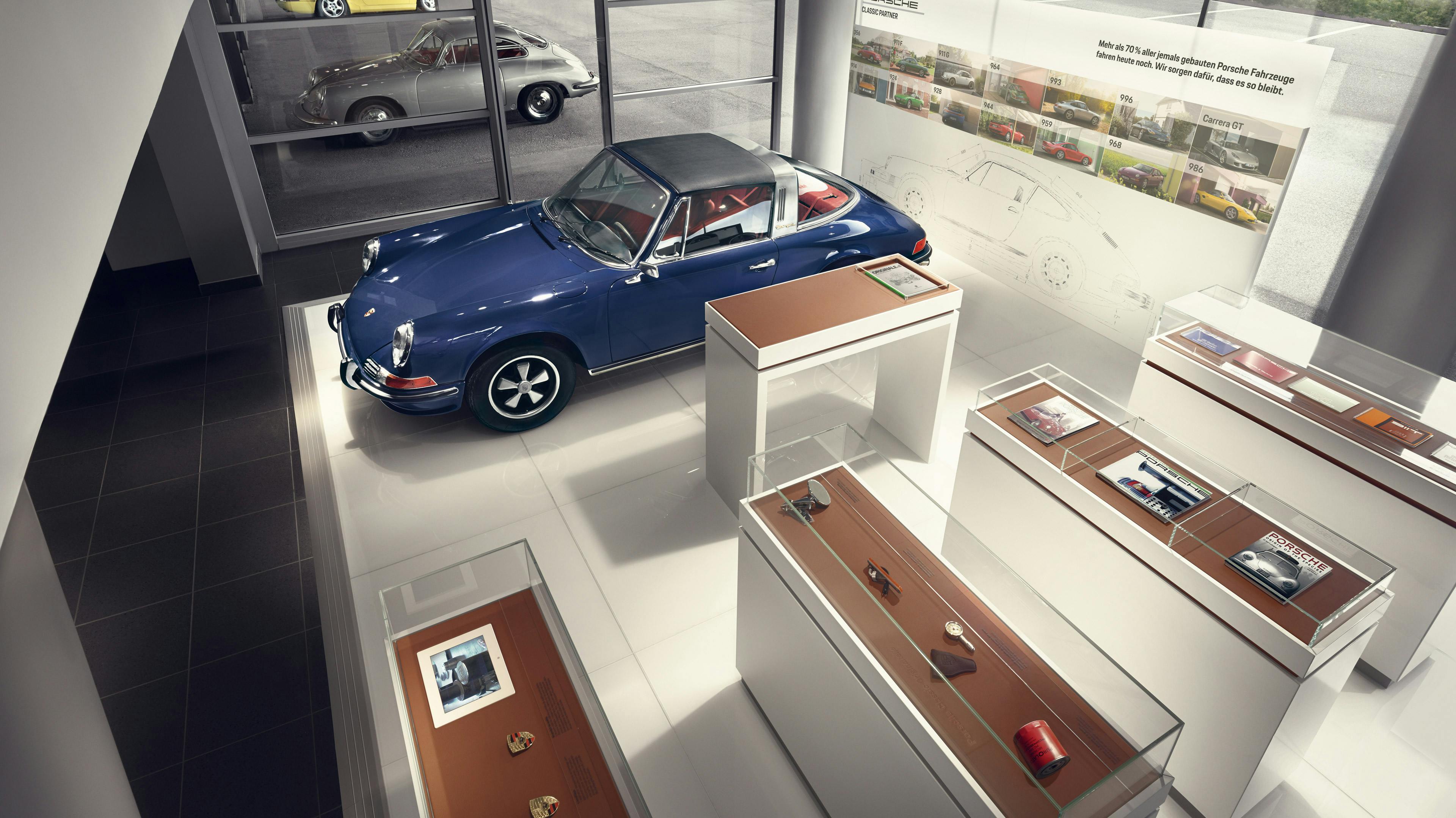 Vitrinen mit Classic Original- und Ersatzteilen, der Porsche Wappenproduktion und technischer Literatur.