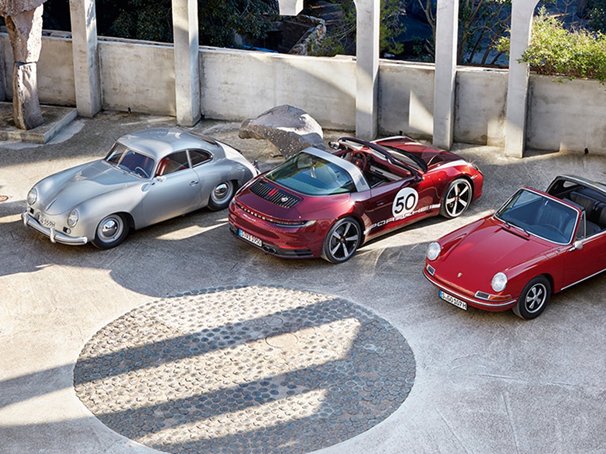 Porsche 911 Targa 4S Heritage Design Edition in Cherry Metallic between two classic Porsche models.