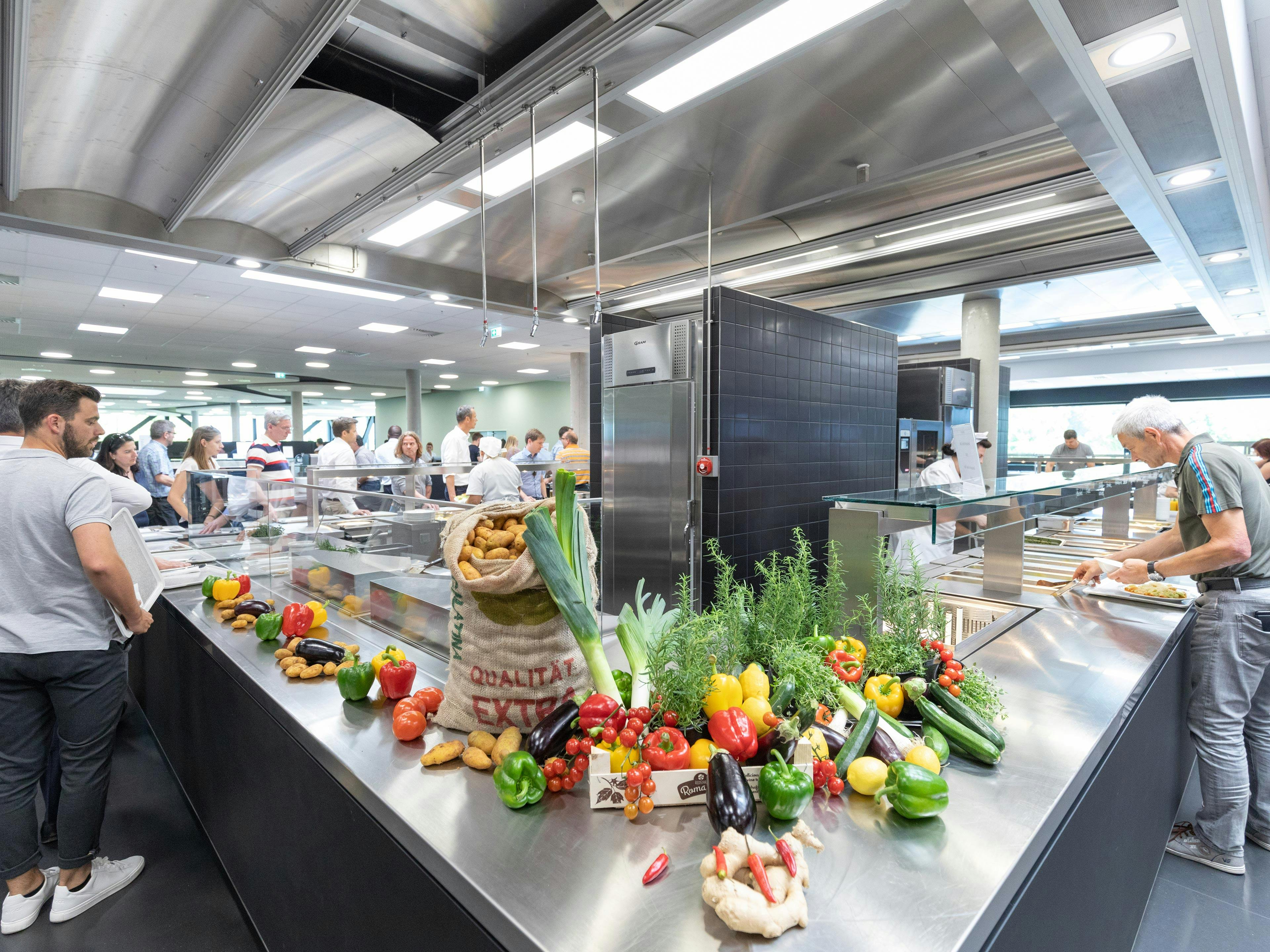 Porsche Cafeteria mit Tischen, Stühlen, Besuchern und gelbem Porsche 911.