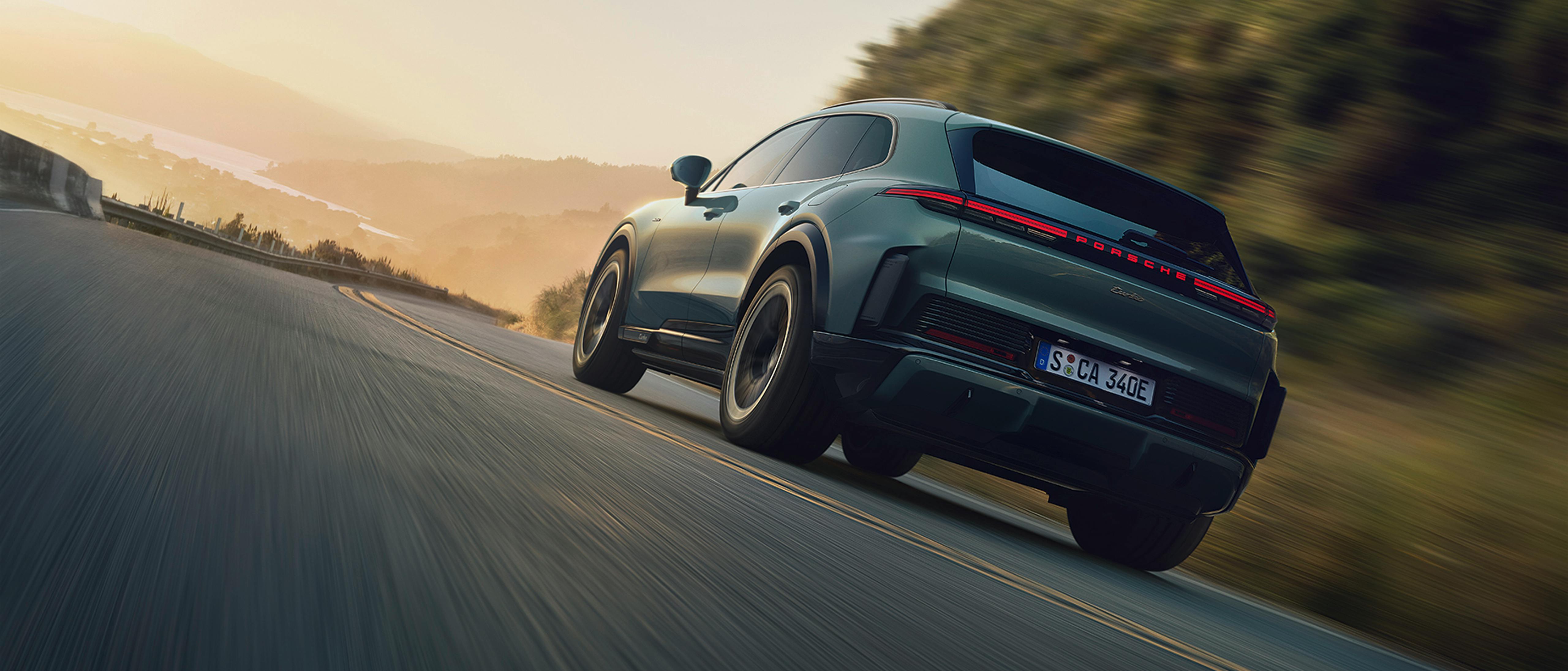 Porsche Cayenne Electric σε δυναμική οδήγηση σε ορεινό δρόμο κατά το ηλιοβασίλεμα (δυναμική οδήγηση σε δρόμο)