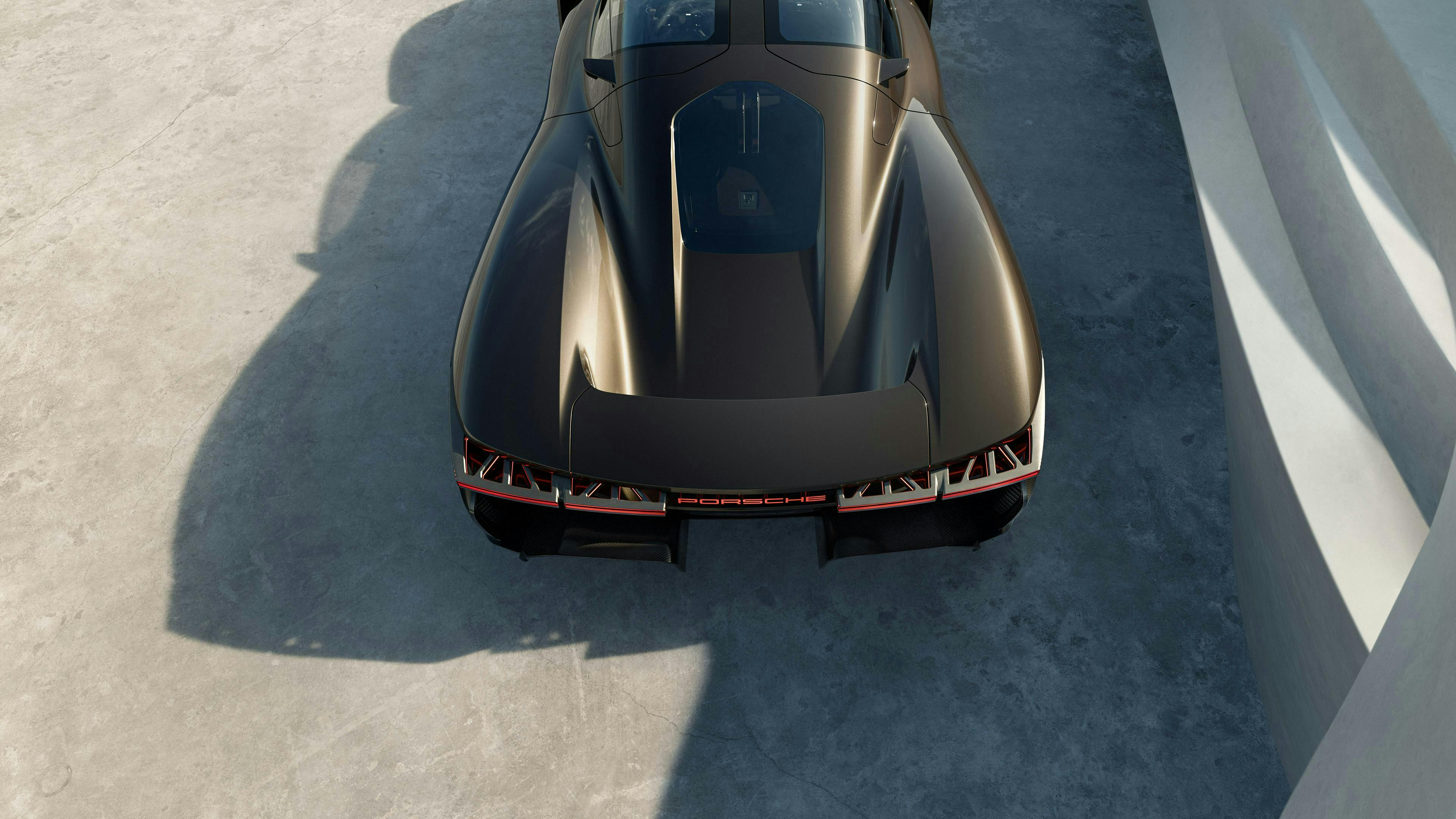 ロケットメタリックのPorsche Mission X 適応的に展開するウイングに焦点を当てて、リアを上から見たビュー