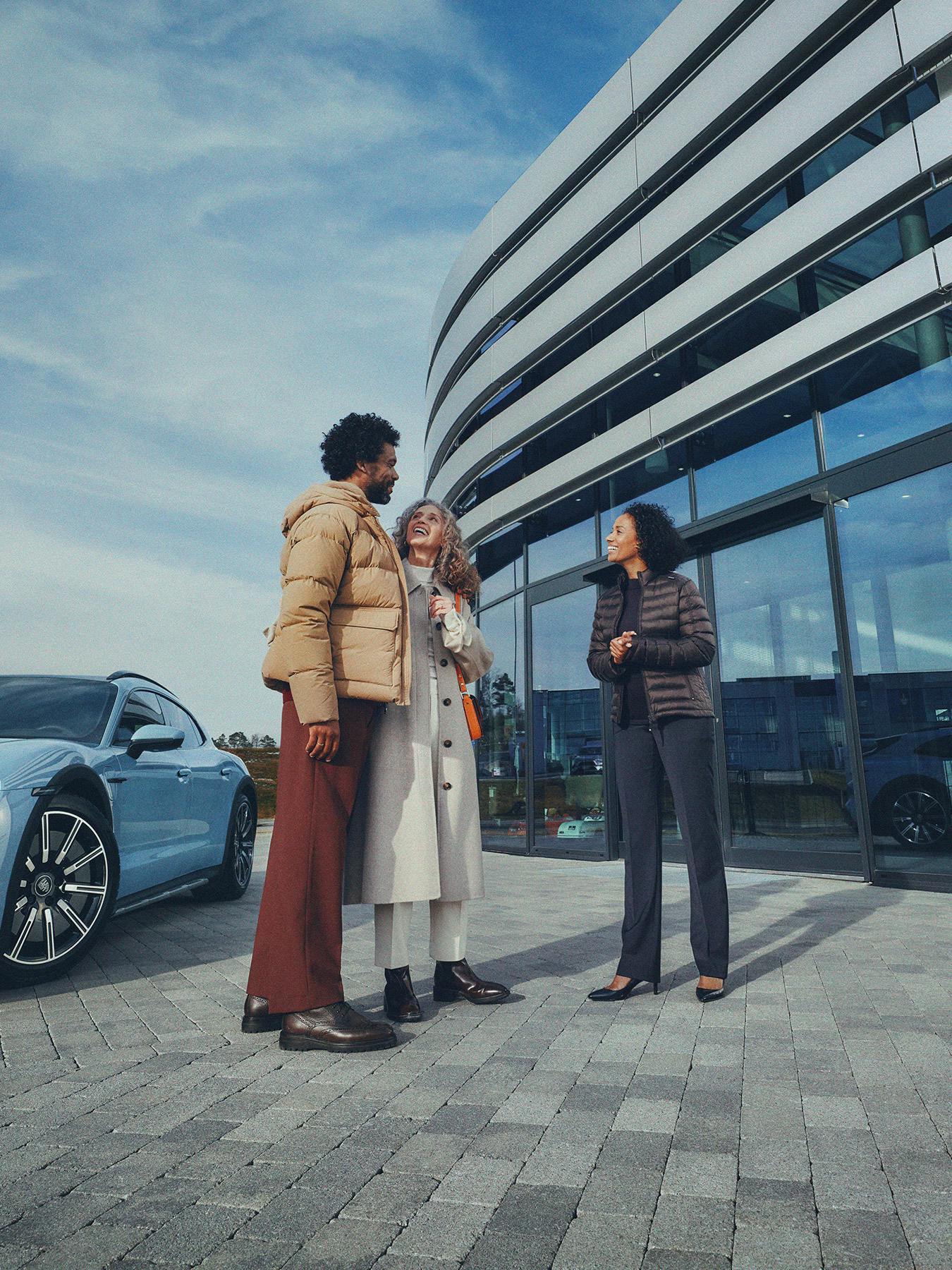 Couple at a Porsche Centre having a conversation with staff member.