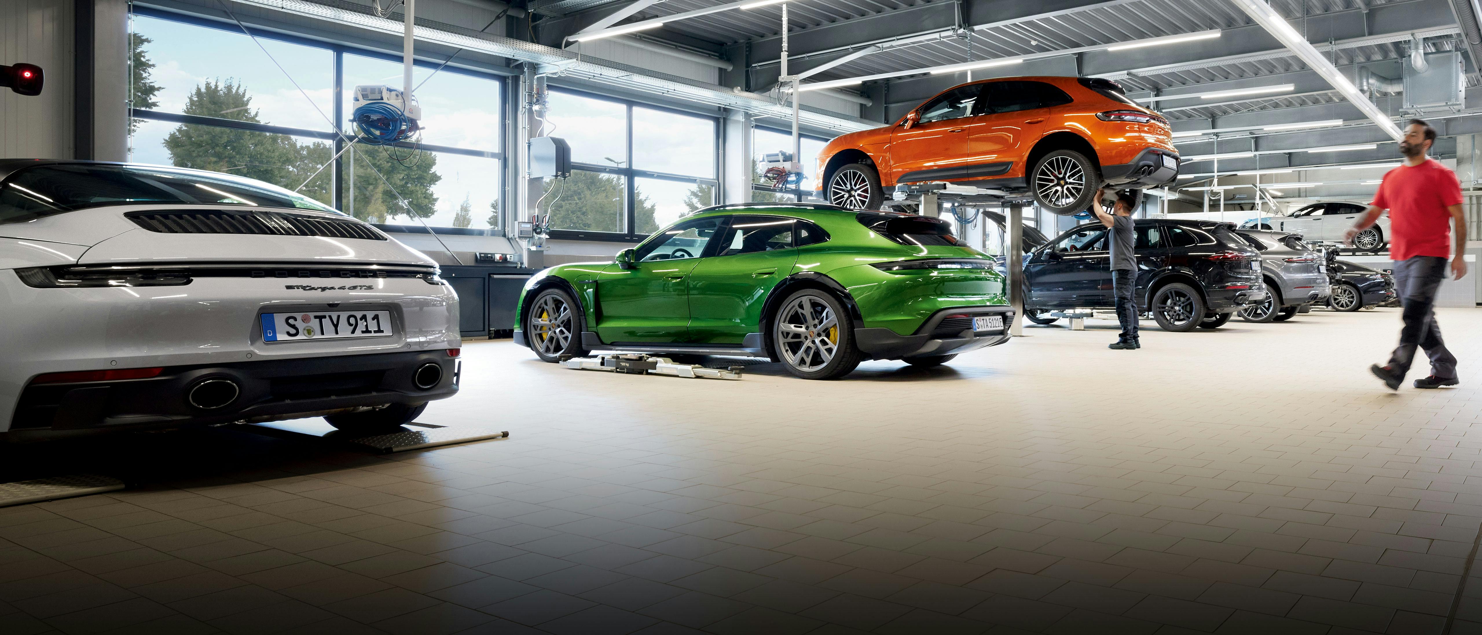 A Porsche service Centre with various models being serviced.