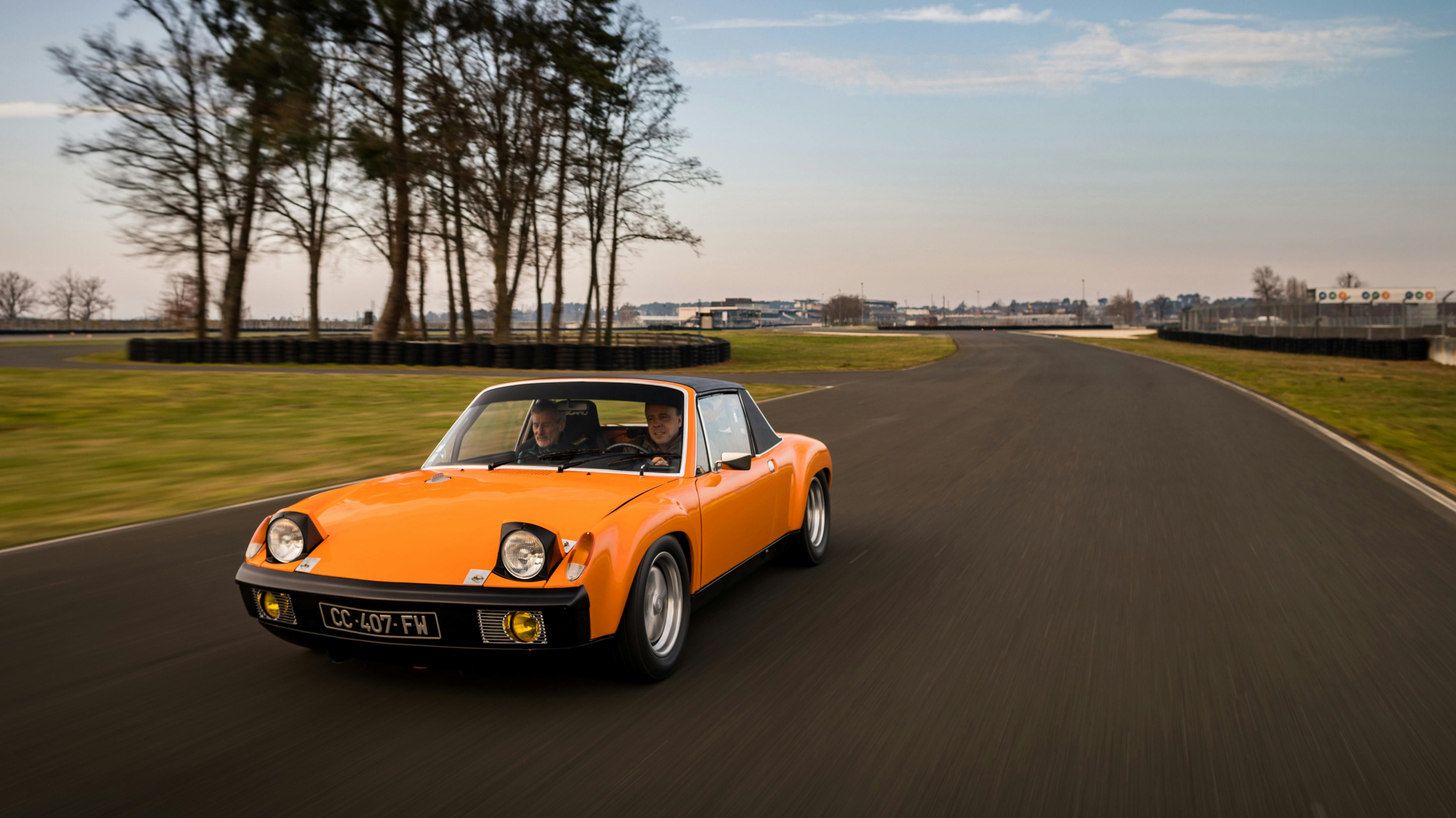 Le véhicule gagnant, une Porsche 914 orange, roule sur le circuit.