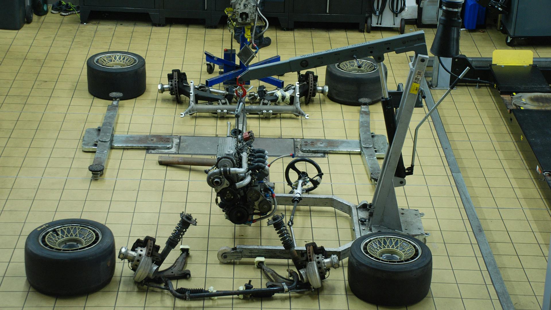 Arranged dismantled wheel and suspension parts lying on the floor of the workshop.