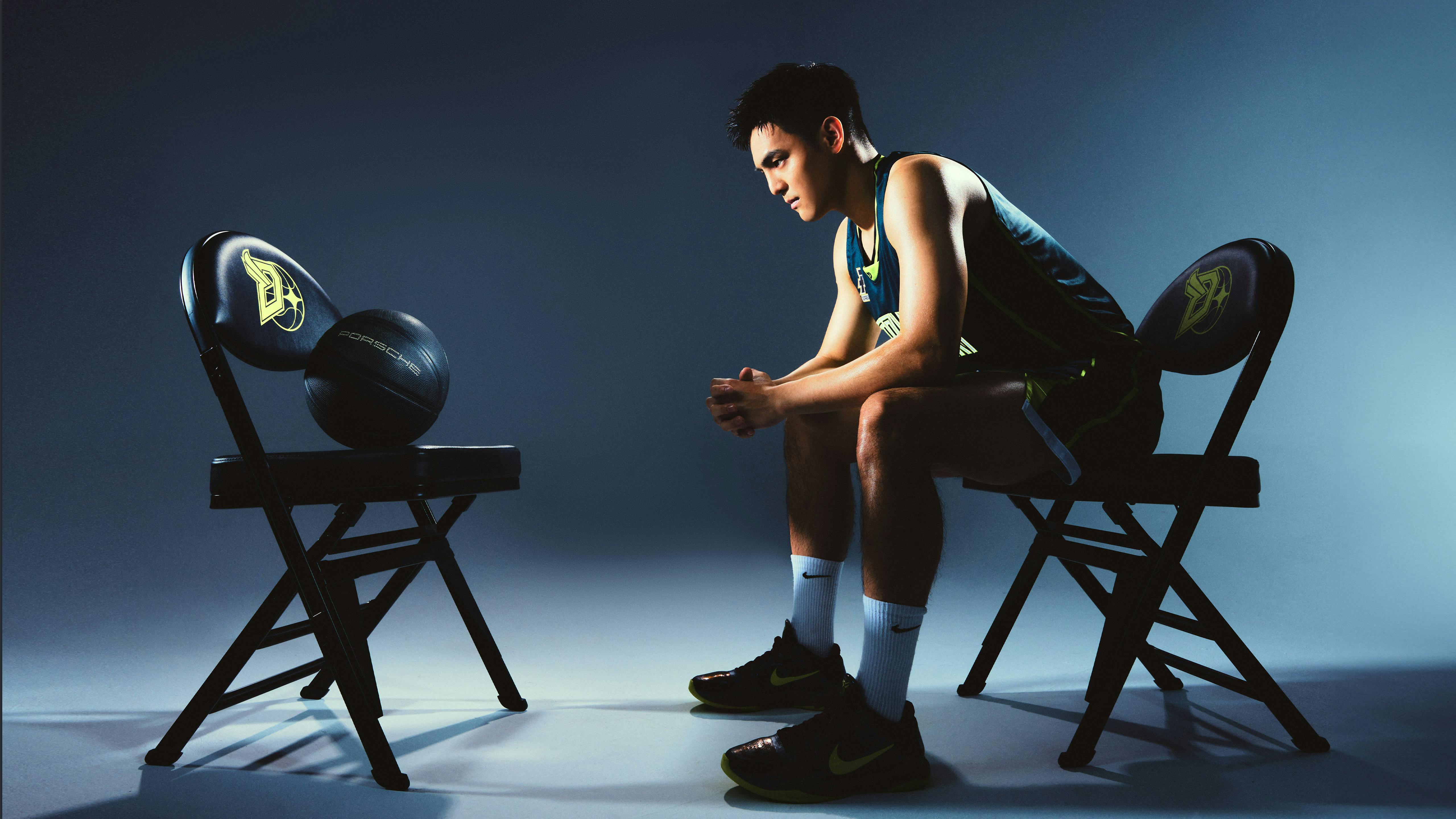 Lin Chun-Chin sitting on a chair and staring at a basketball.