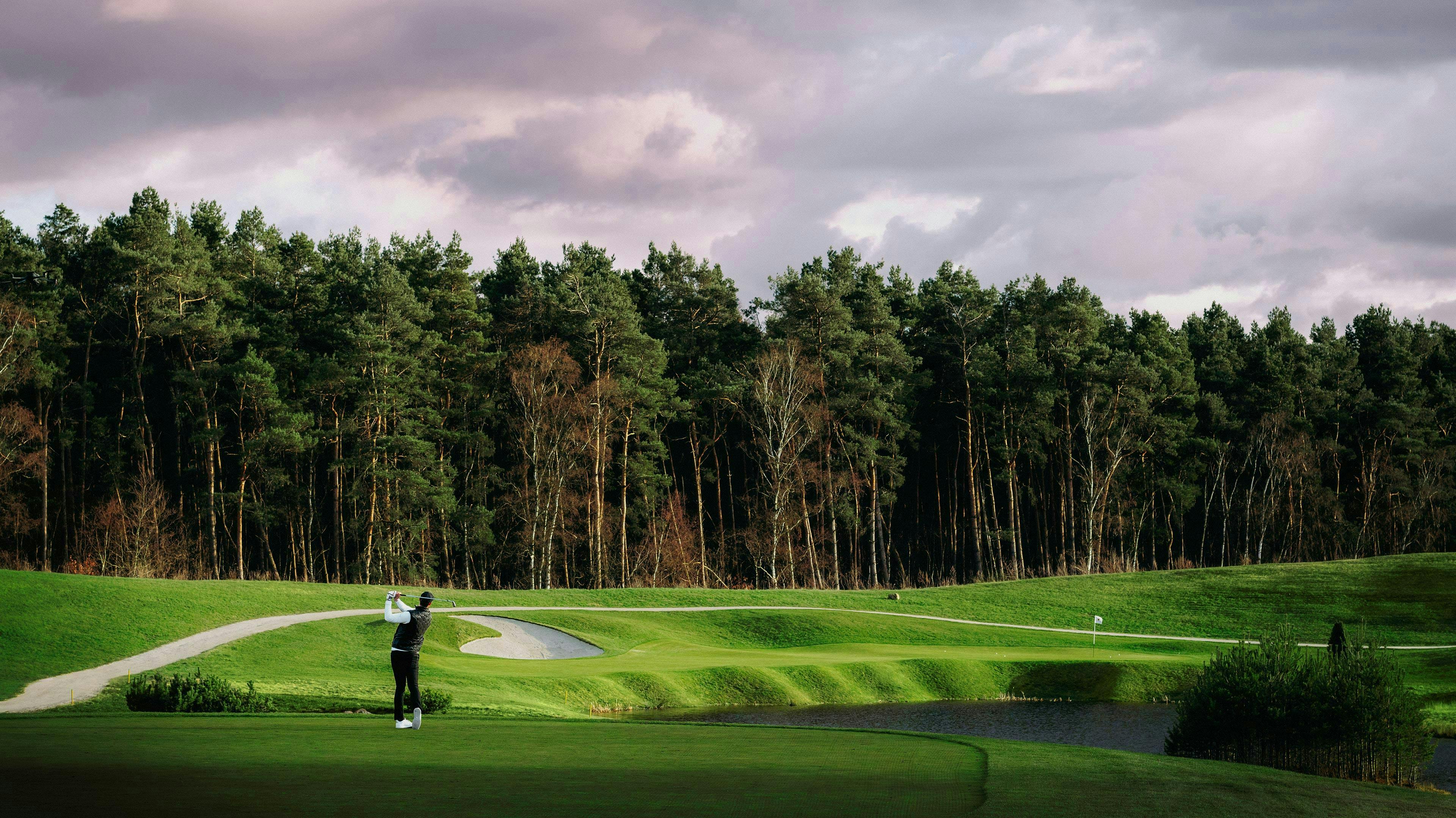 Golfer verfolgt mit seinem Blick den abgeschlagenen Ball