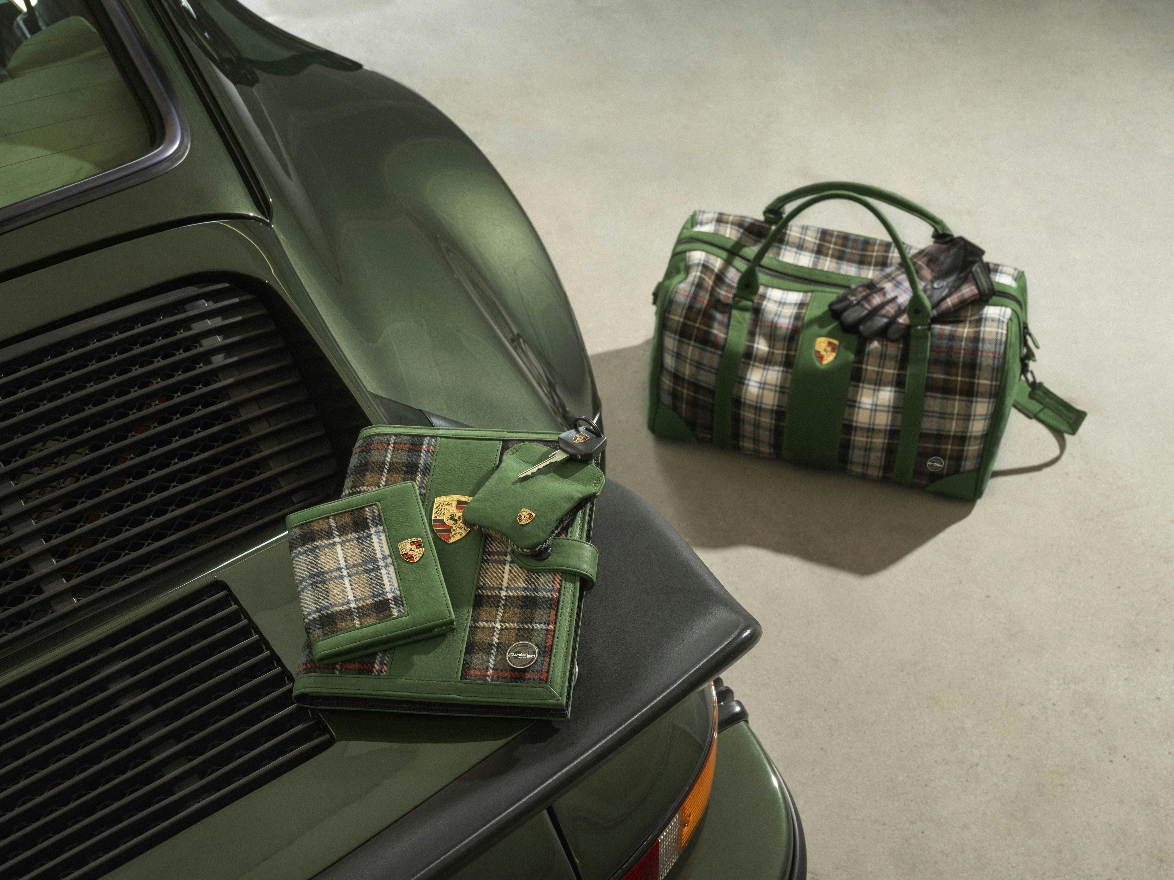 Accessories in a green tartan pattern standing next to and on the rear of a green, classic 911 Turbo
