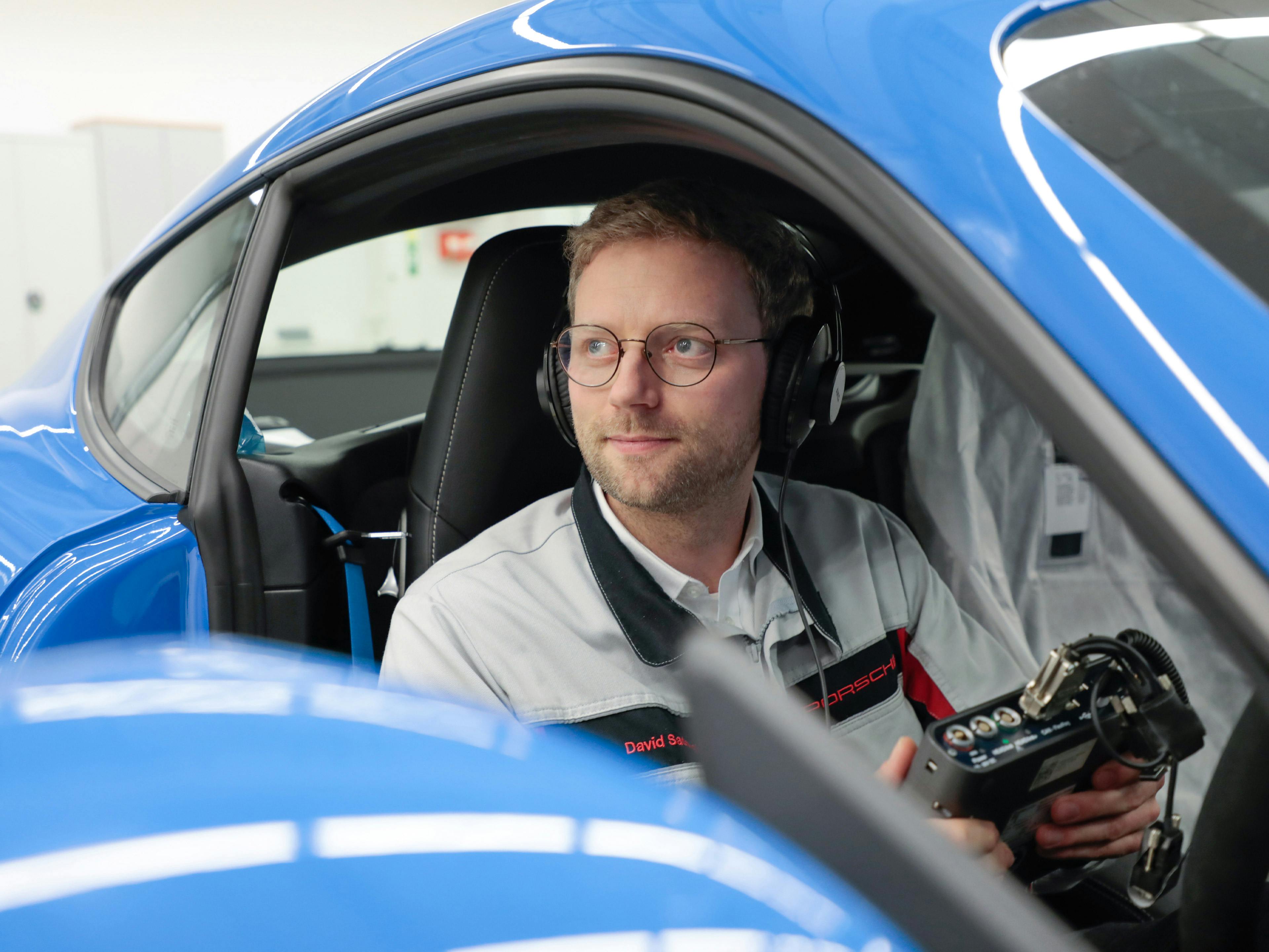 Der Porsche Mitarbeiterin David sitzt in einem Fahrzeug und prüft die Akustik.