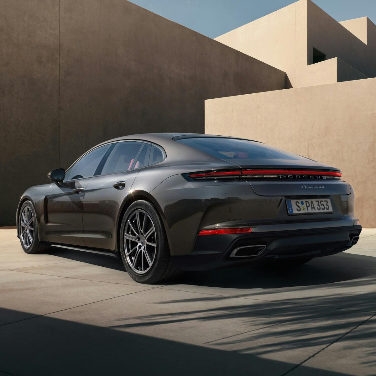 A grey Panamera parked in front of buildings.