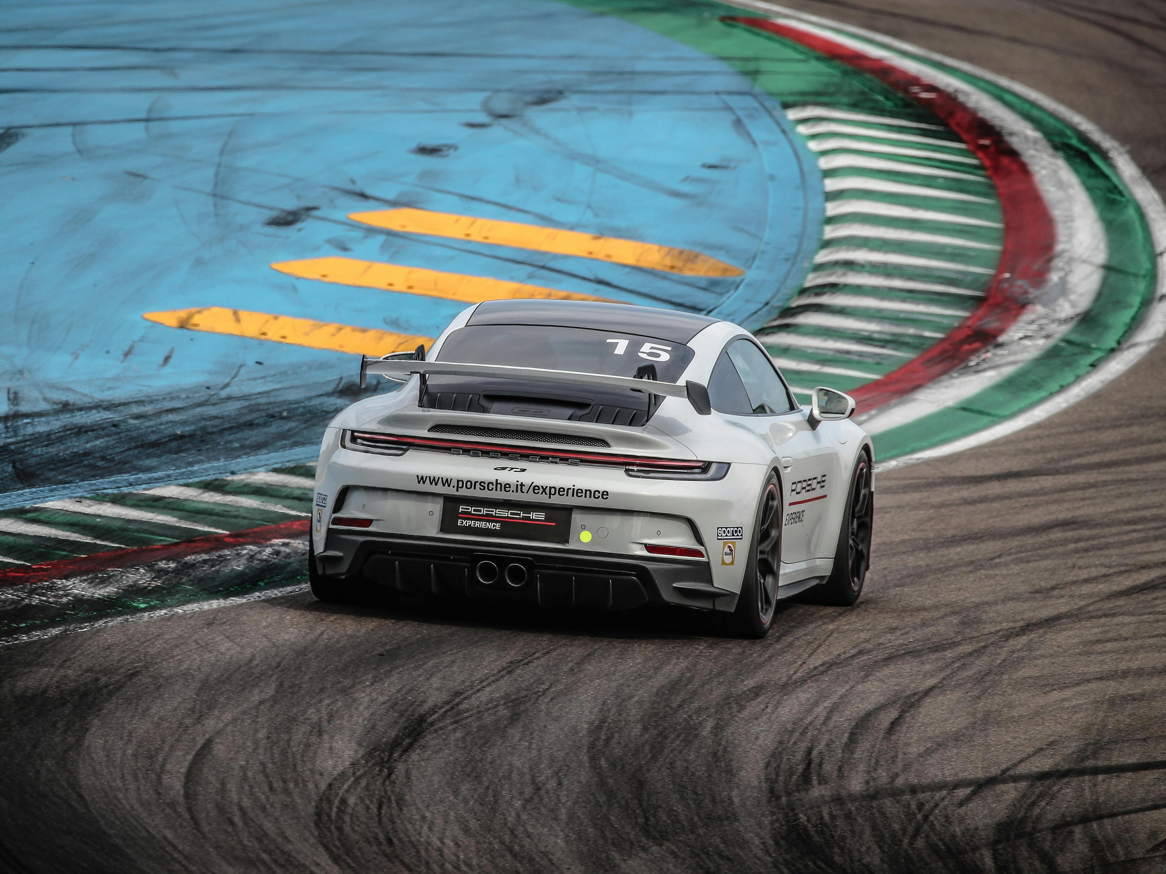Una Porsche 911 sta correndo sulla famosa curva 'Acque Minerali' nell'adrenalinico autodromo di Imola.