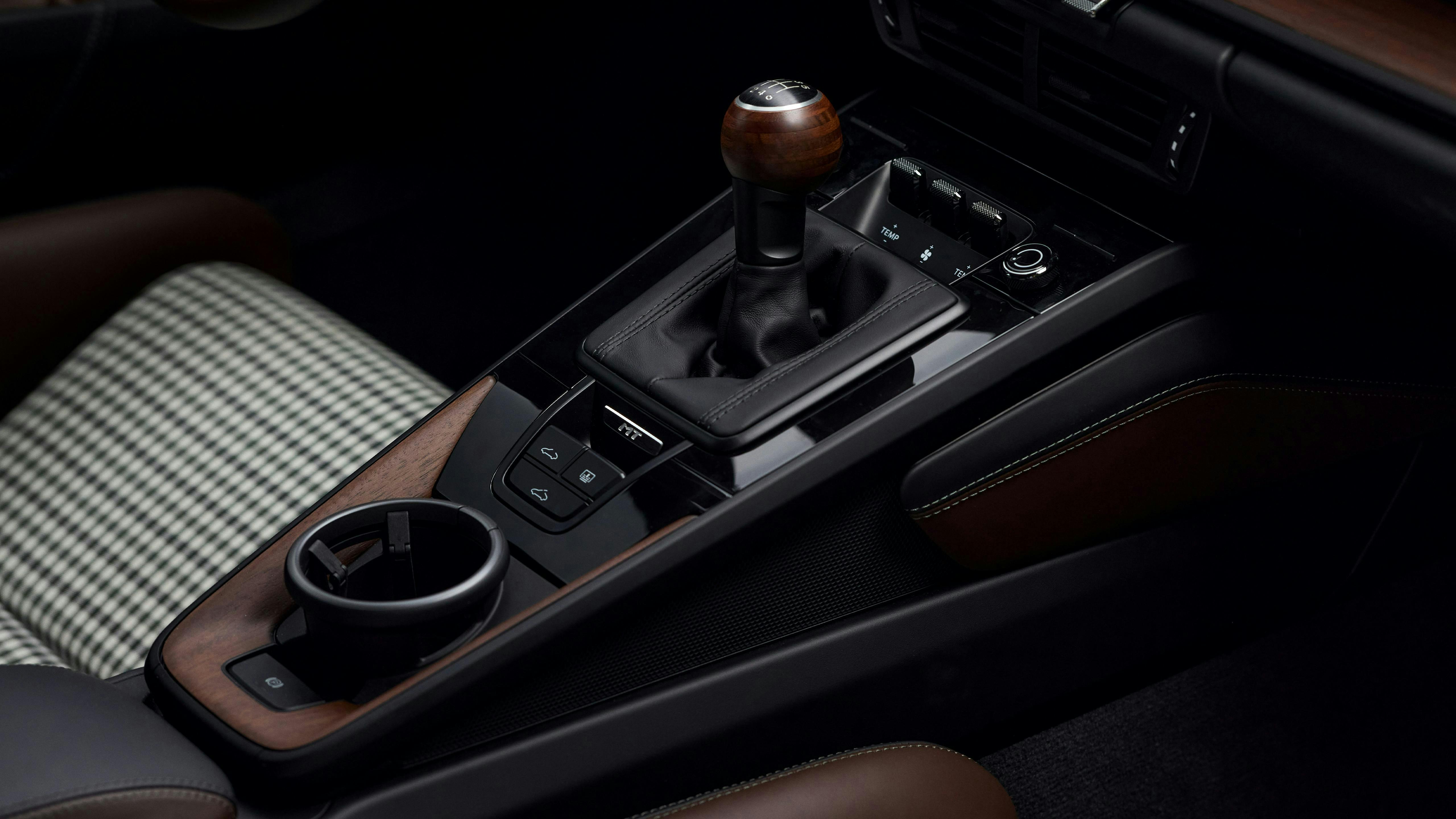 Porsche 911 Carrera 中控台細節，帶手排排檔桿、杯架及控制按鈕。