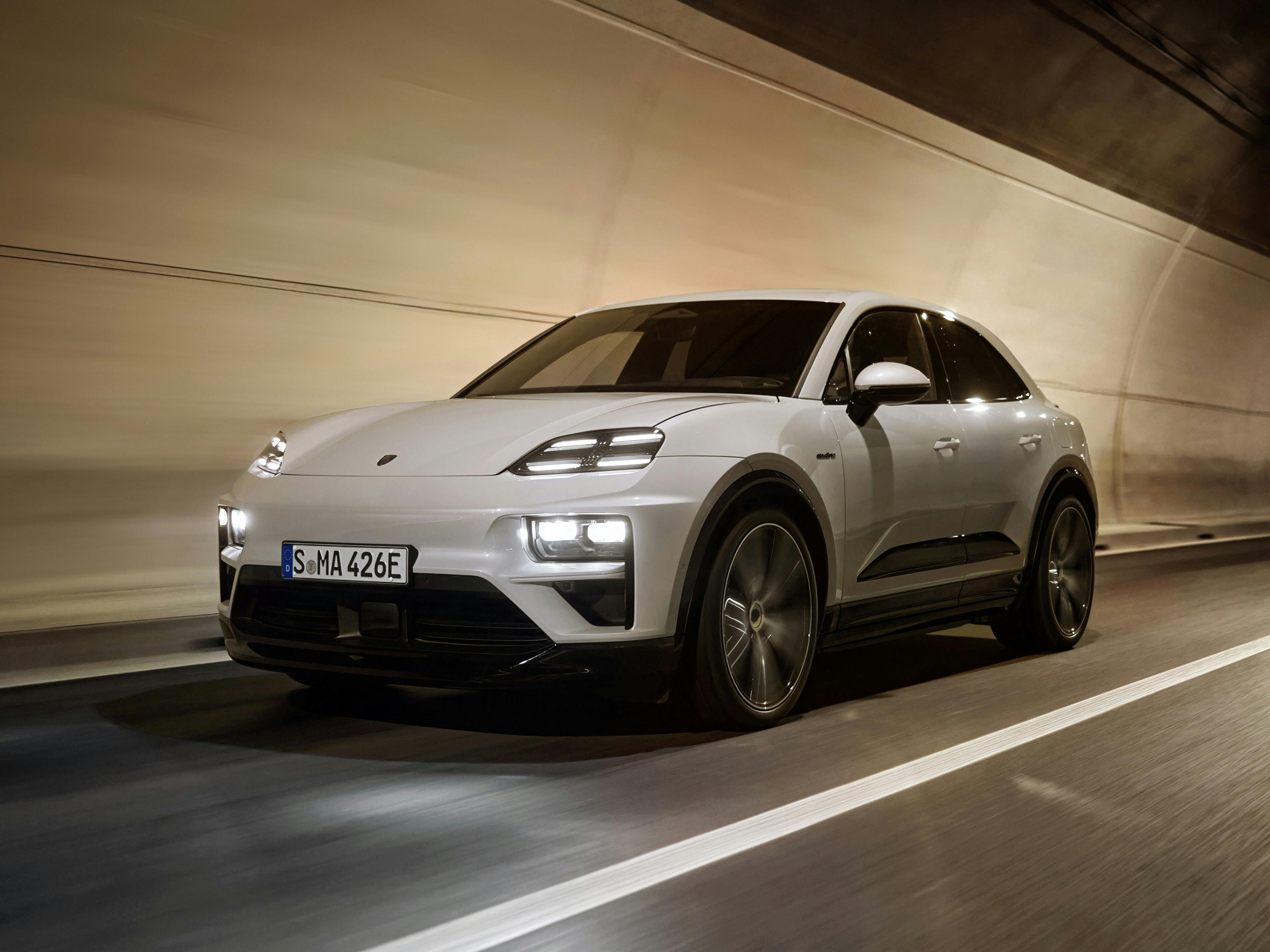 White Porsche Macan driving on highway through tunnel.