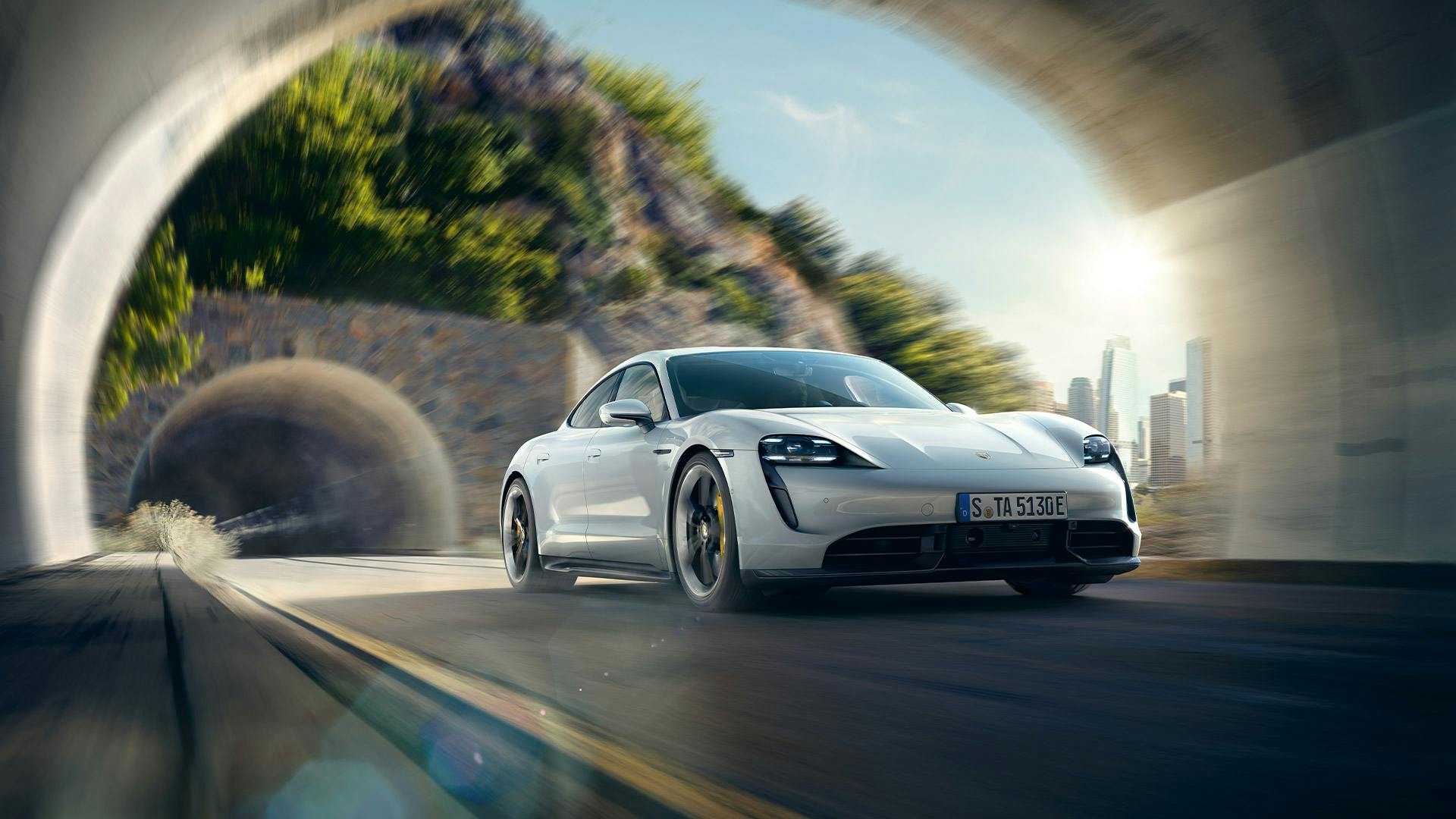 Ein weißer Porsche Taycan fährt in einen Tunnel.