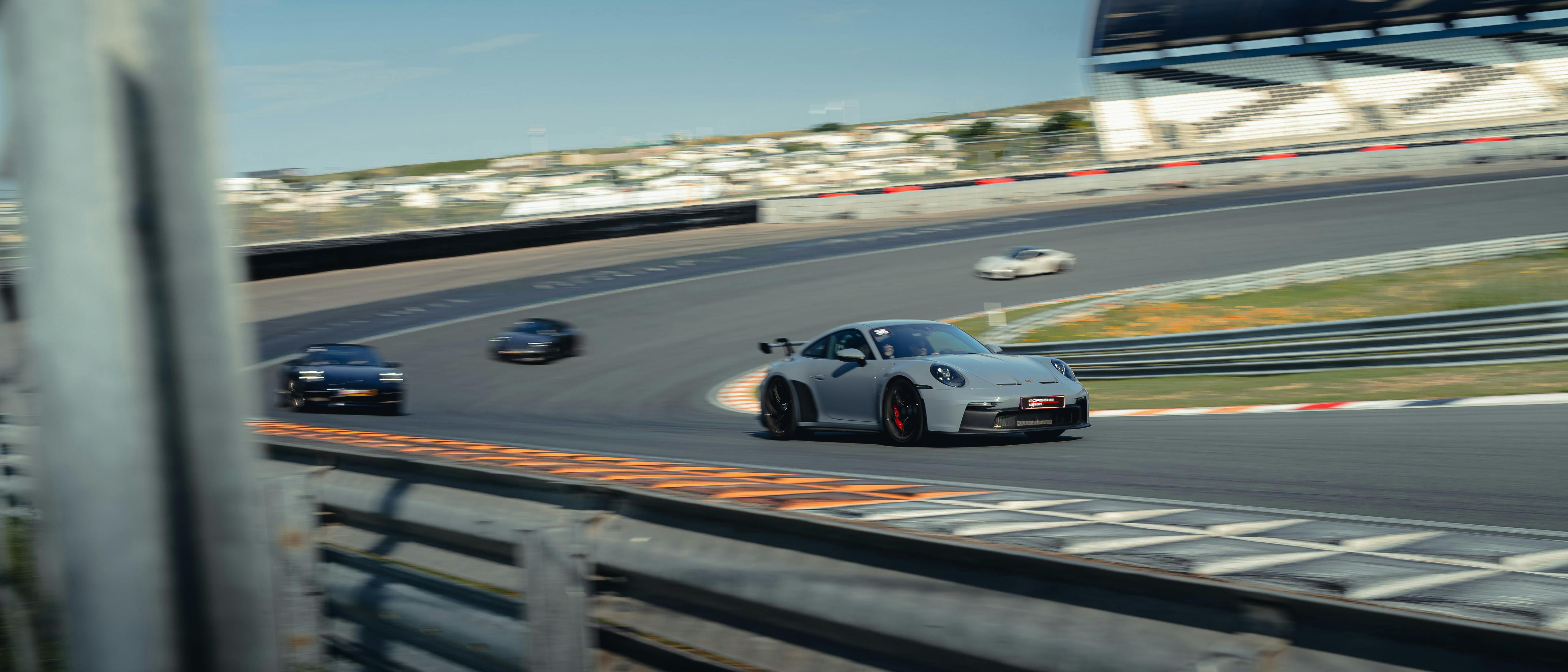 Verschillende Porsche auto's rijden op het circuit tijdens de Porsche Track Experience