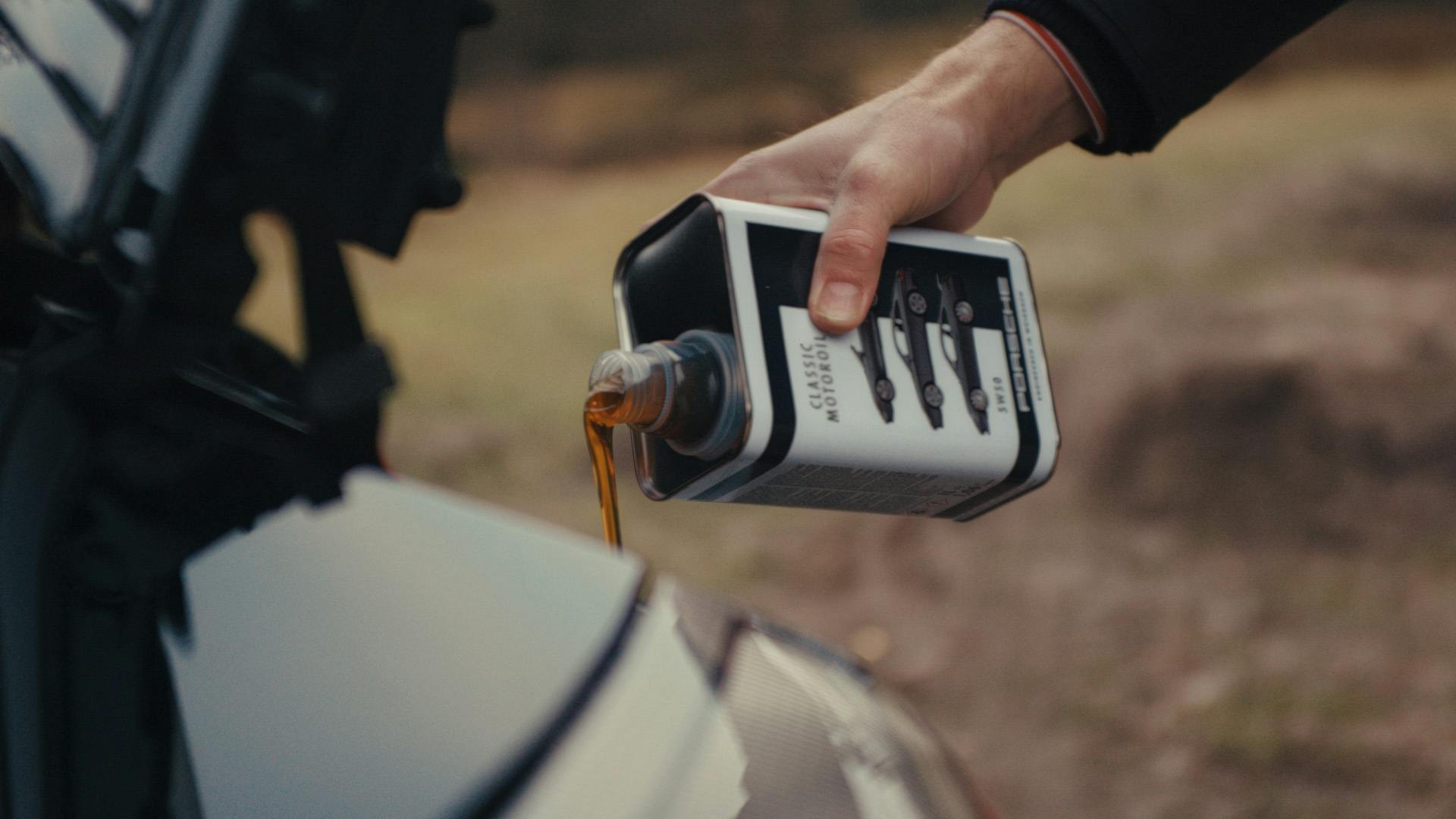 Man fills his black 911 Type 996 with Porsche Classic Motoroil 5W50.