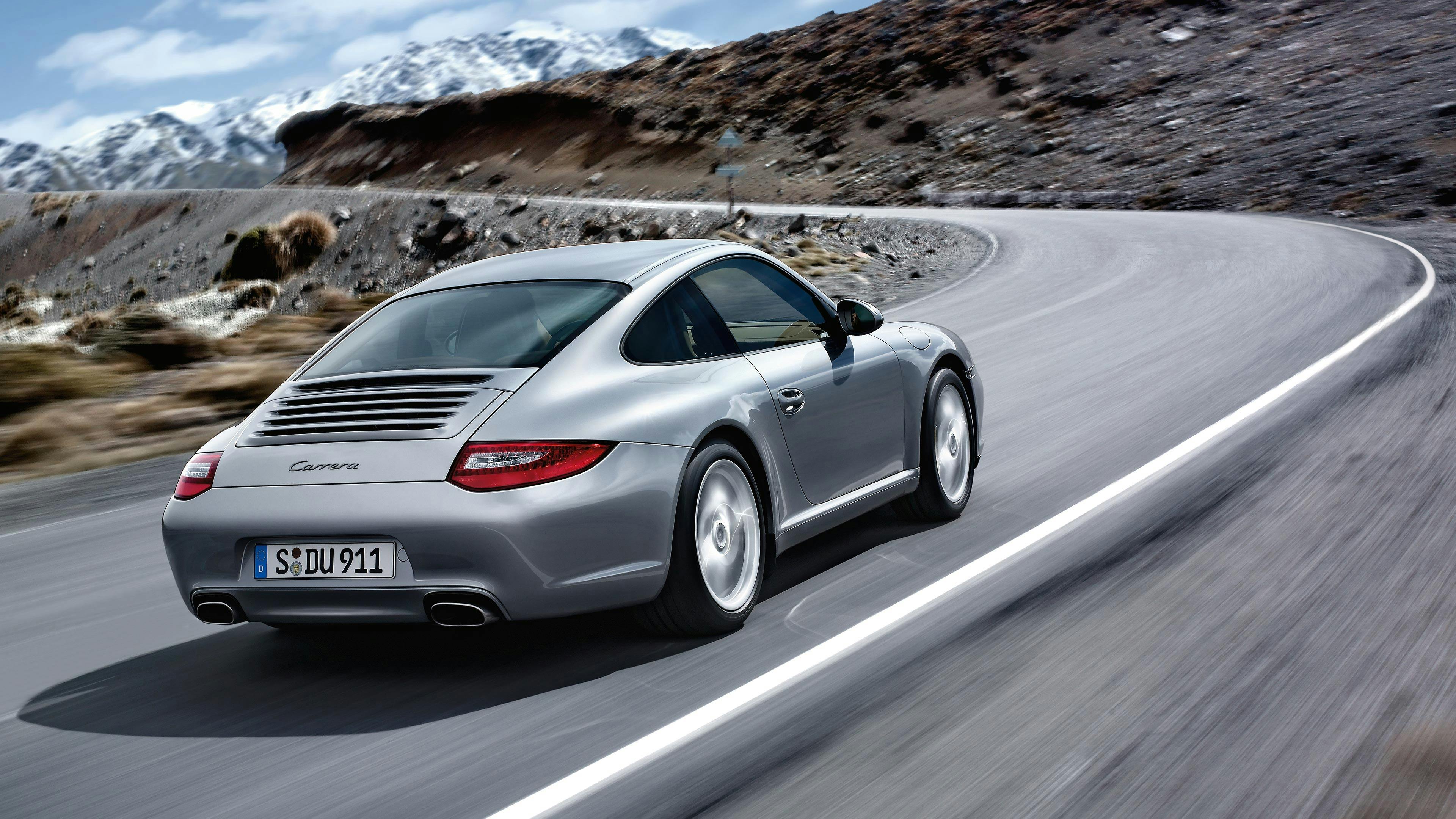 Driving 911 Carrera Coupé type 997 on a mountain road.