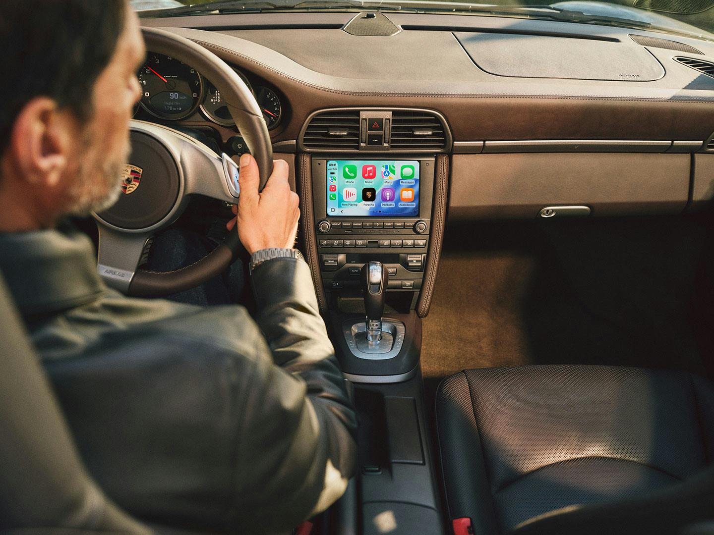 Fahrer nutzt PCCM Plus mit Apple CarPlay® auf dem Bildschirm.