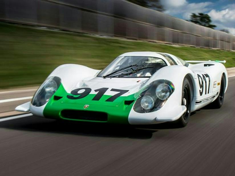 A white and green Porsche 917 number 917 racing on track.