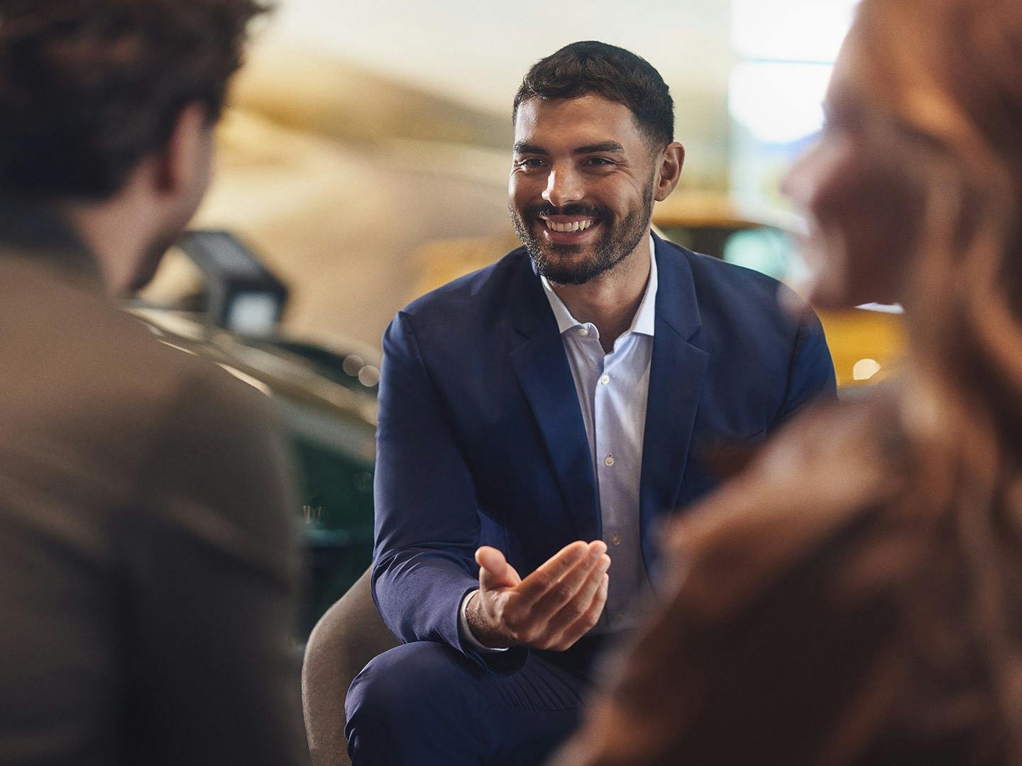 Smiling employee speaking to two customers