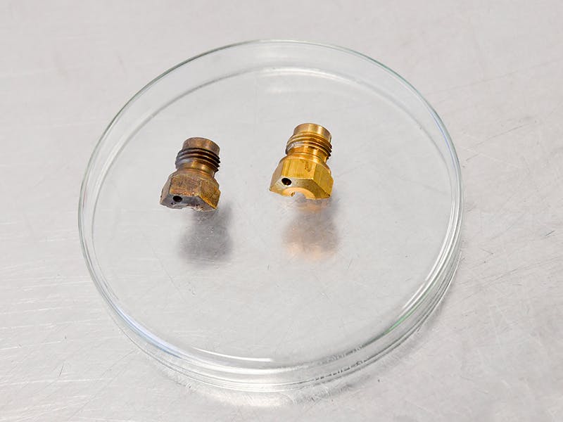 Petri dish with two small Classic Genuine Parts.