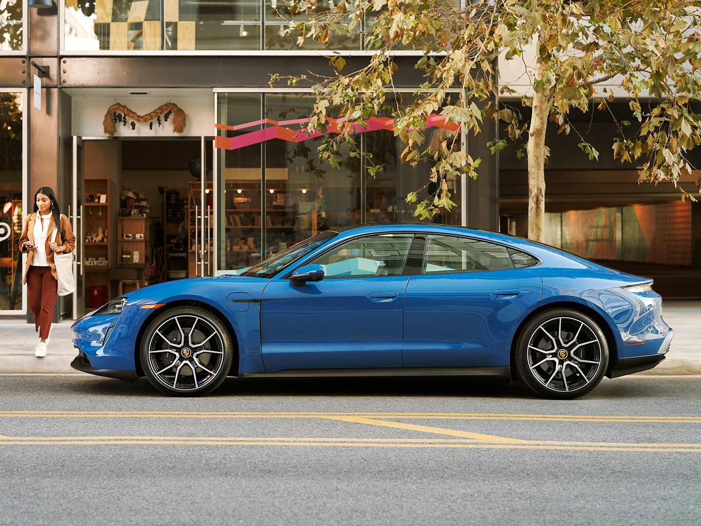 Blue Porsche Taycan parked on a city street.
