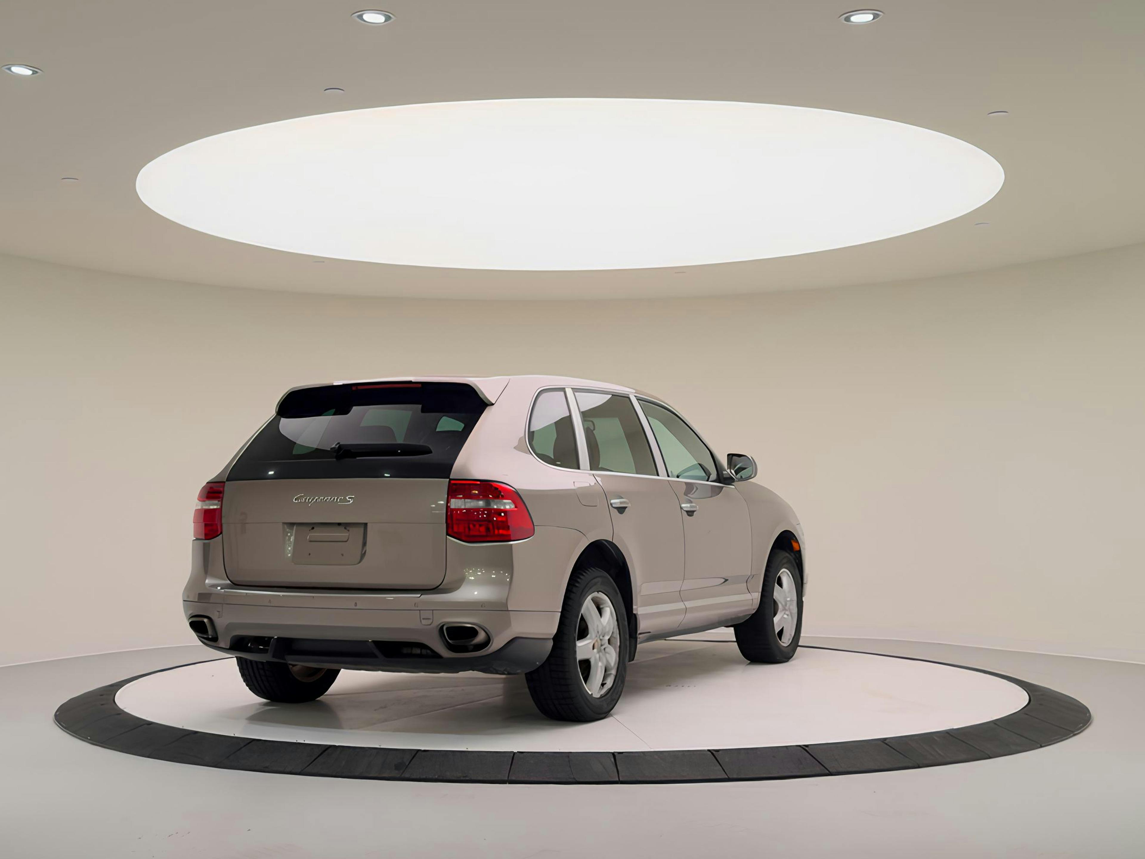 KW – A Porsche Cayenne viewed from the rear on a rotating platform in a showroom.