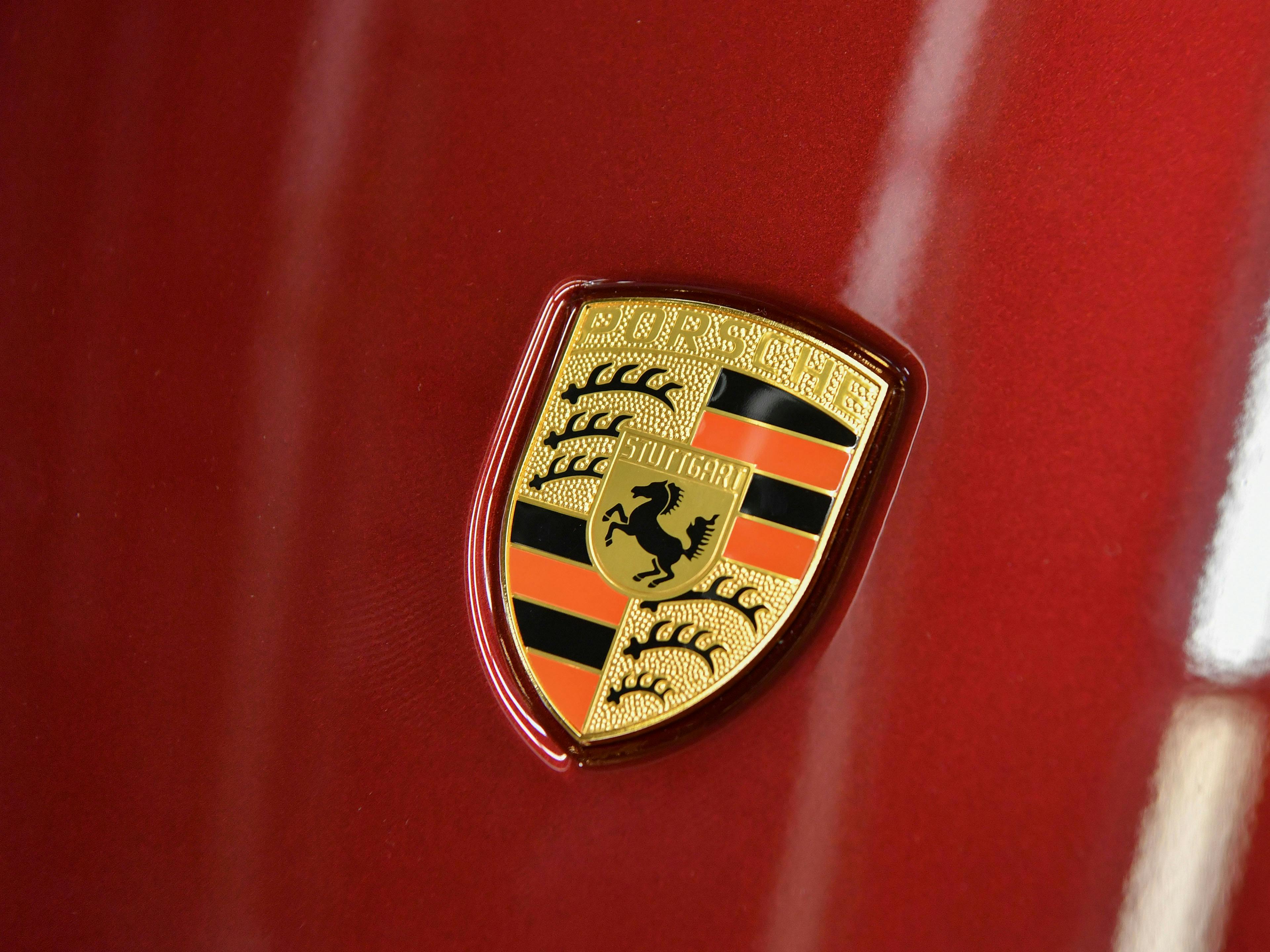 Porsche Wappen mit Stuttgarter Rössle und goldenem Porsche Schriftzug.