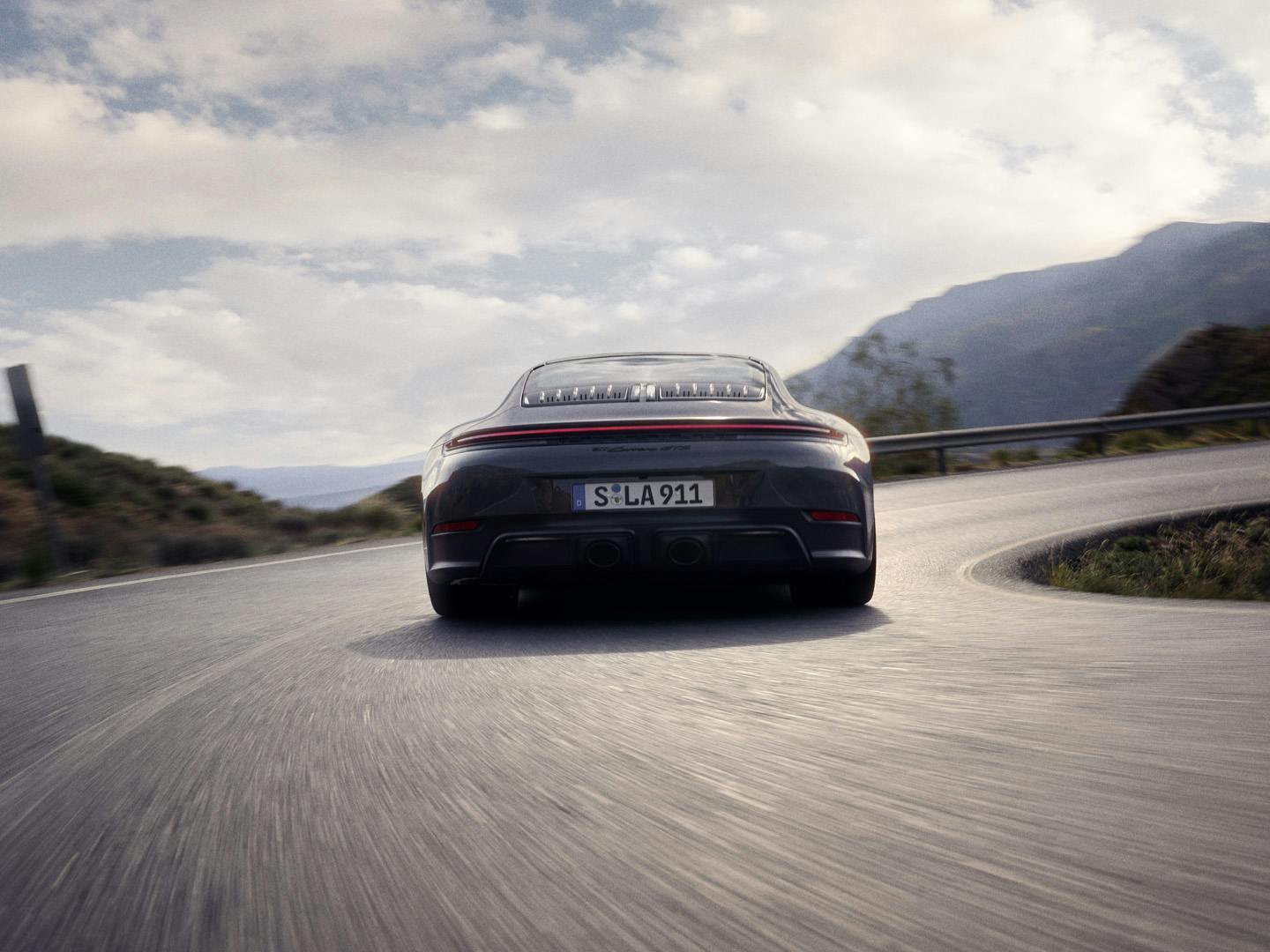 En Porsche 911 Carrera GTS kör på vägbanan i en skarp sväng.