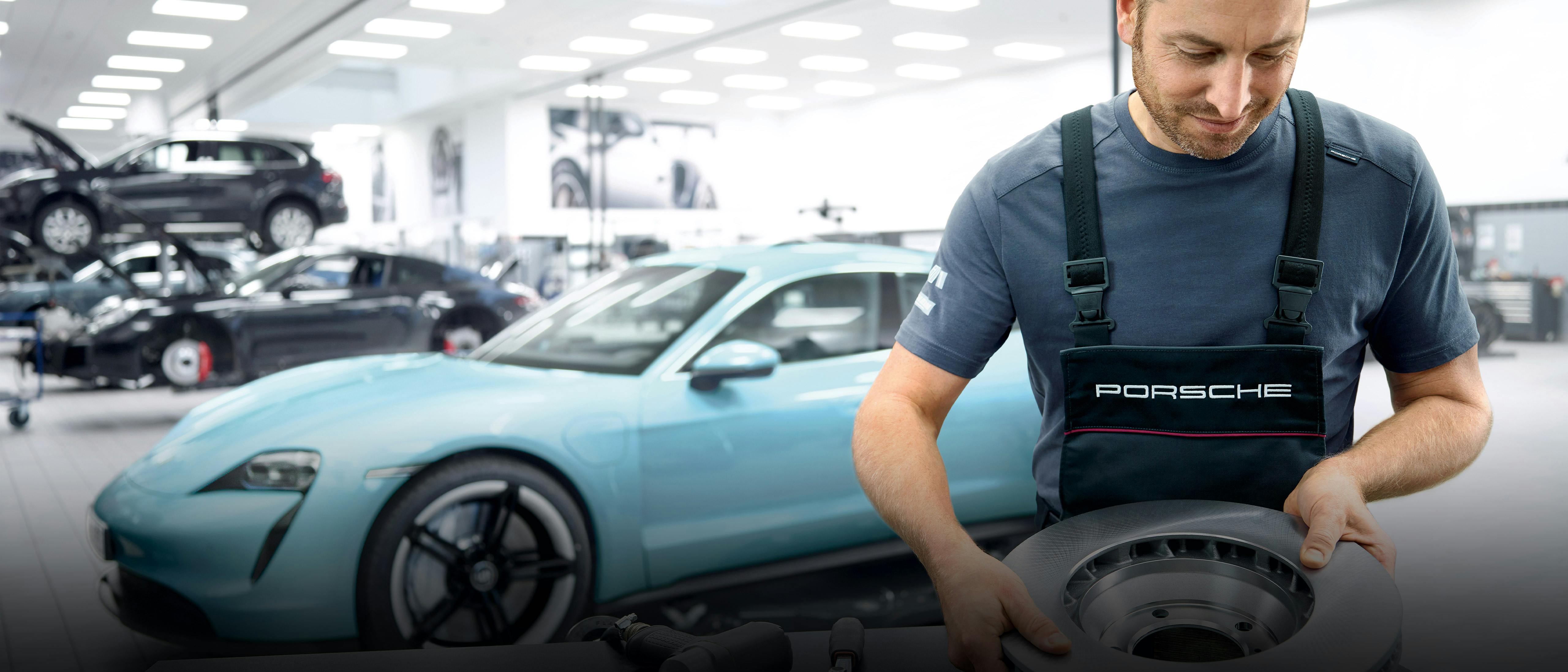 Mecánico revisando los frenos en un taller Porsche.