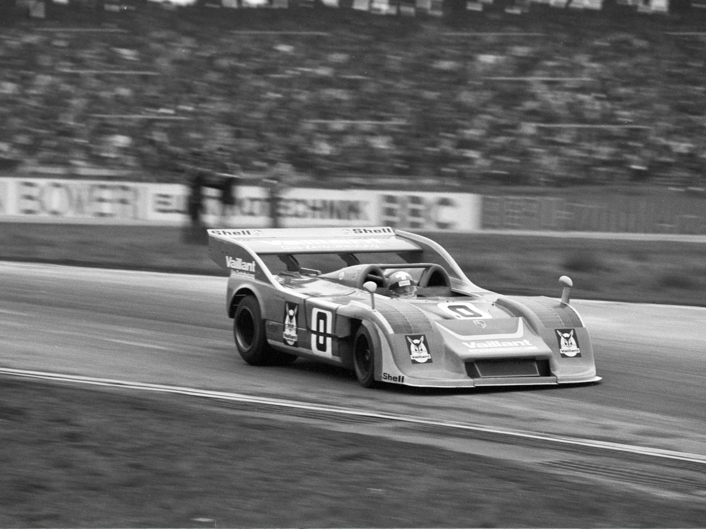 A period black and white photograph of the open‑cockpit Porsche 917/30 racing at speed on track.