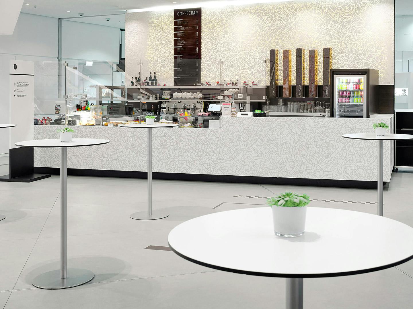 Die Coffeebar im Porsche Museum mit mehreren runden Stehtischen vor der Theke.