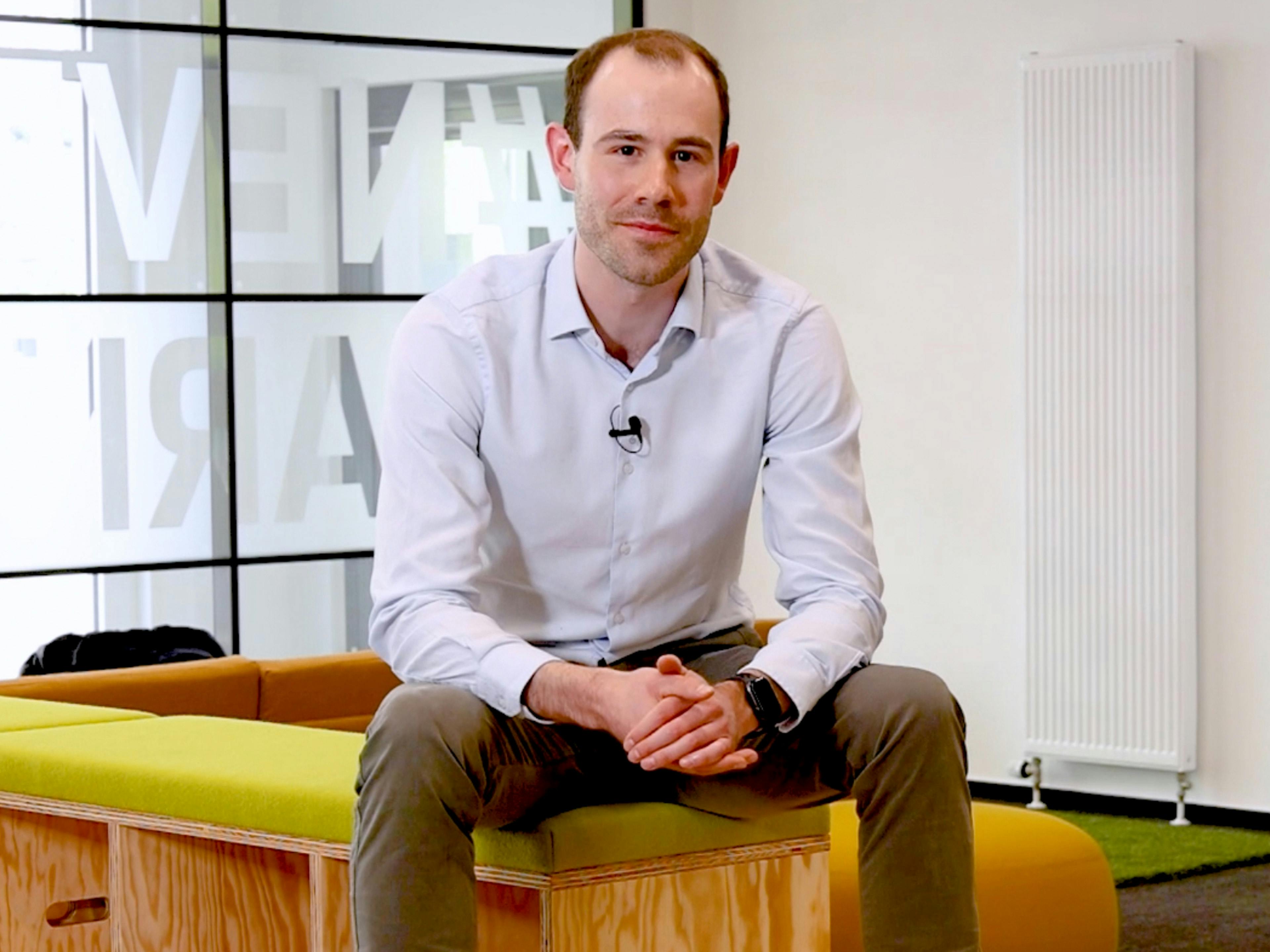 Der Porsche Mitarbeiter Yannick berichtet von seinem Job im Bereich KI in einem Aufenthaltsraum.