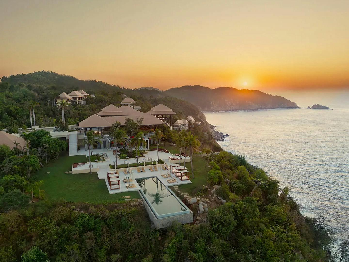 Aerial view of the Hotel Banyan tree in Acapulco overlooking ocean at sunset.