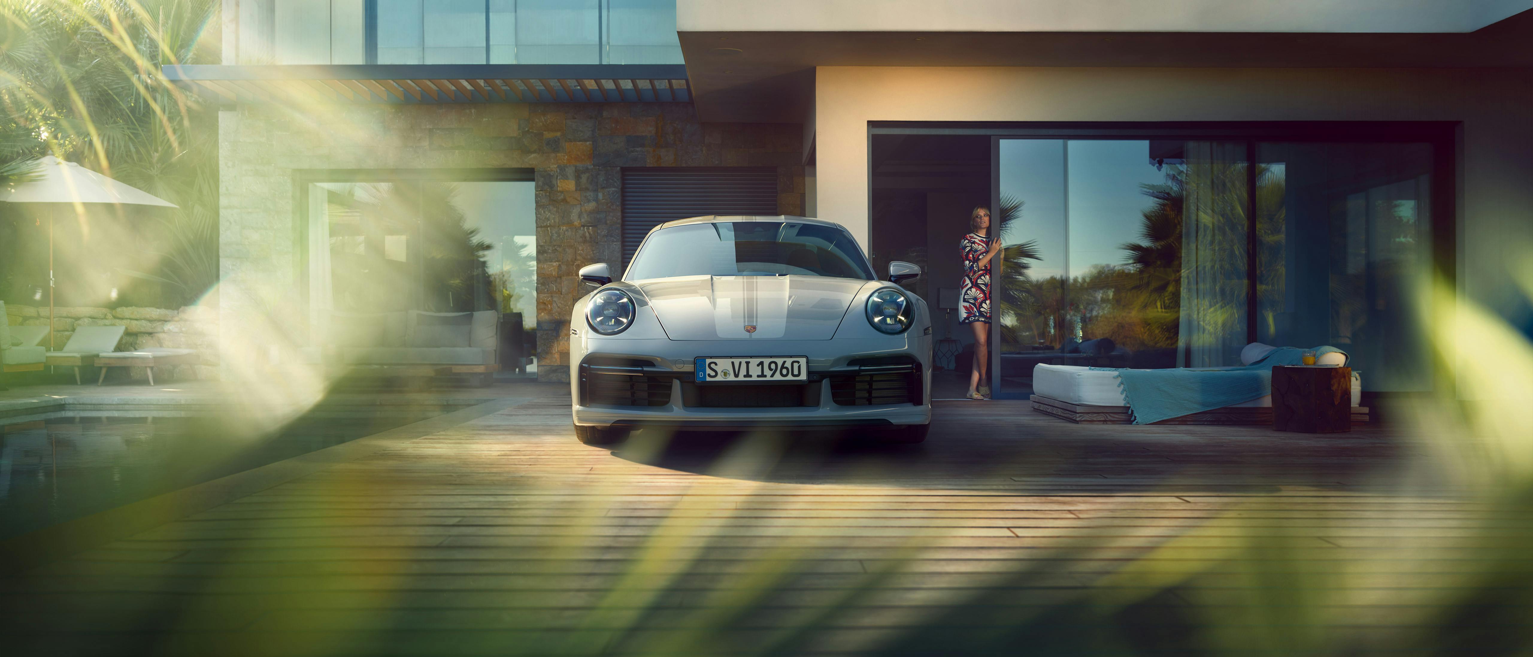 Une Porsche 911 Sport Classic garée devant une villa.