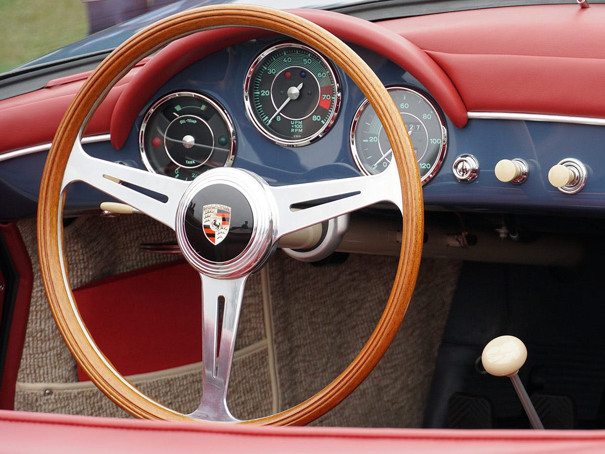 Vue intérieure d'une Porsche 356 Cabriolet mettant en valeur le volant et les composants du tableau de bord.
